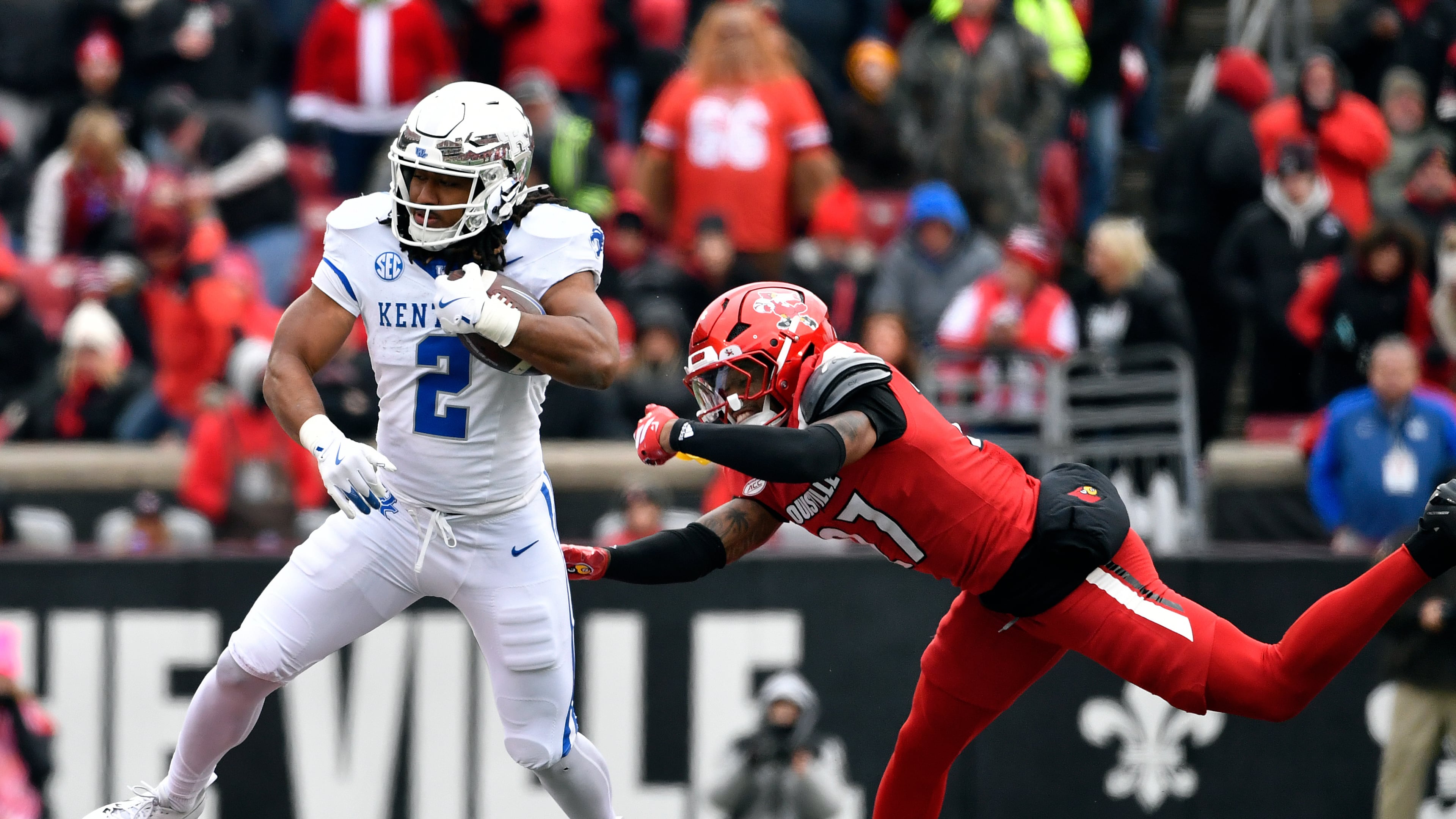 FILE - Kentucky running back Dante Dowdell (2) avoids the tackle attempt by Louisville defensive back Jojo Evans Jr. (27) during the second half of an NCAA college football game in Louisville, Ky., Nov. 29, 2025. (AP Photo/Timothy D. Easley, File)