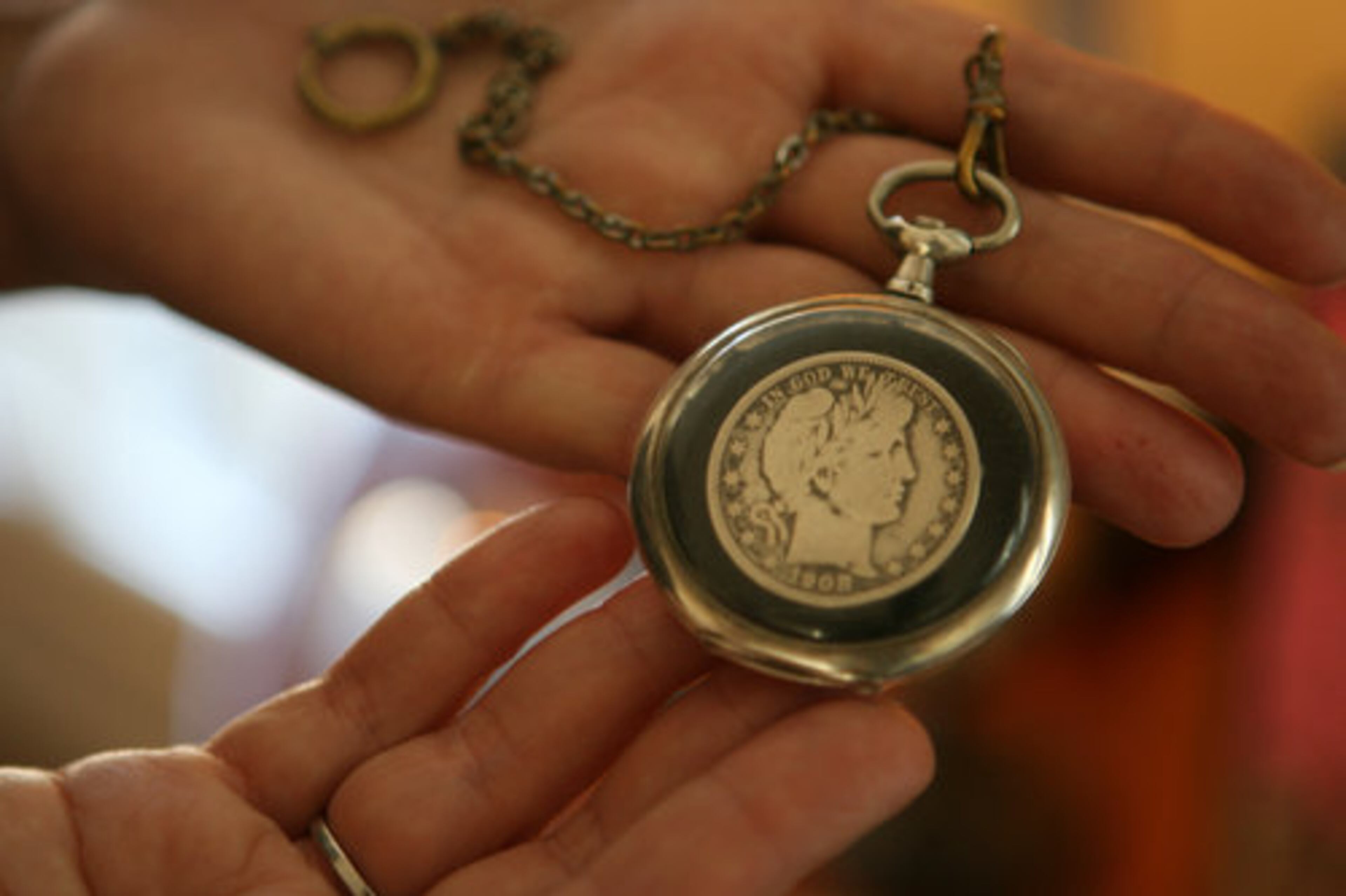 Susan Gibbs holds an original 1908 silver dollar coin that she found in the house during its renovation.