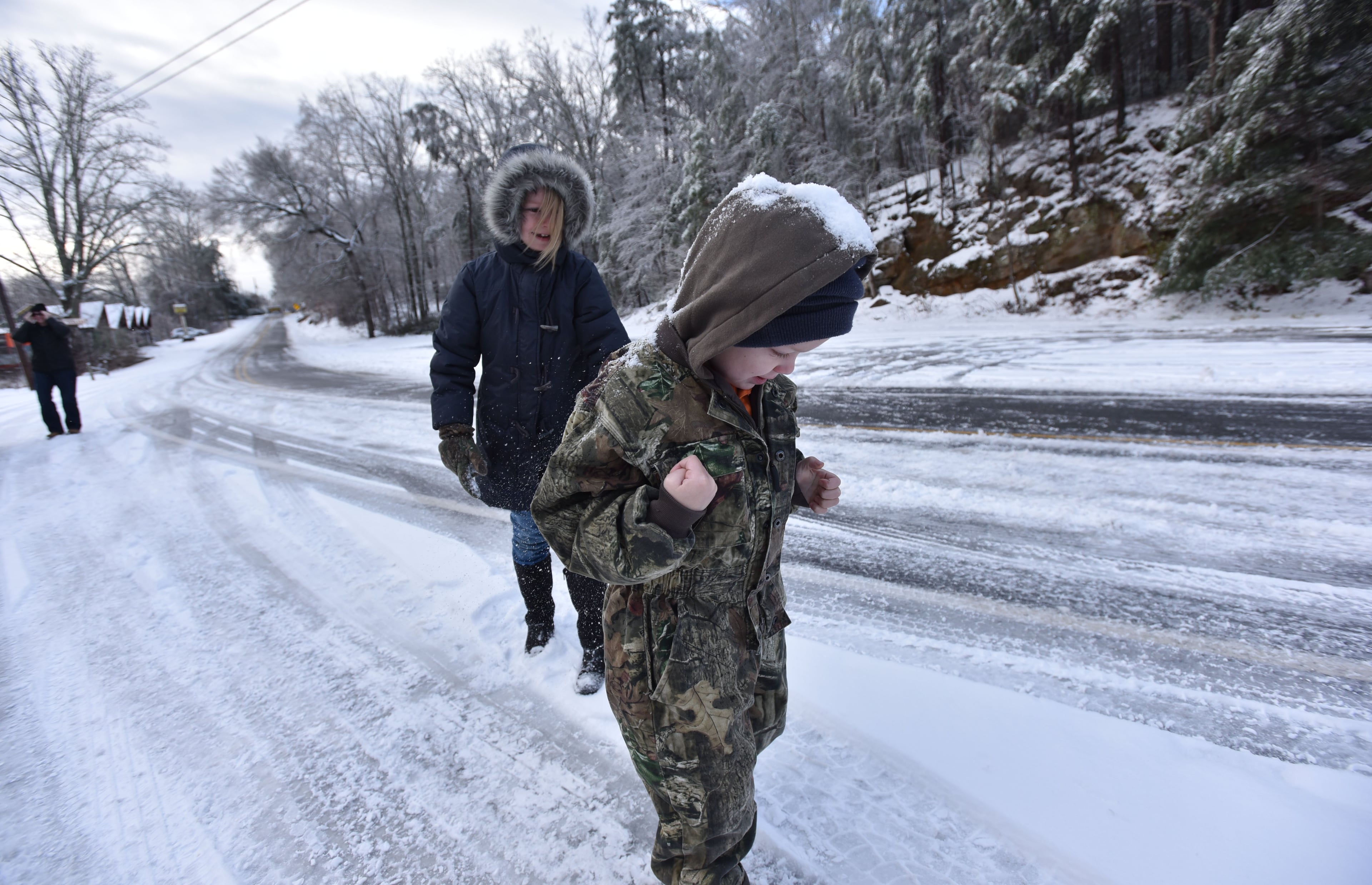 Ellie Poe, 8, and her brother Owen, 6, play in the snow near Tallulah Gorge State Park on Saturday morning, January 23, 2016. The winter storm that moved in Friday afternoon brought sleet and freezing rain across the metro area. Then came the snow, and late Friday night, more snow. And finally, temperatures hit the freezing mark. HYOSUB SHIN / HSHIN@AJC.COM