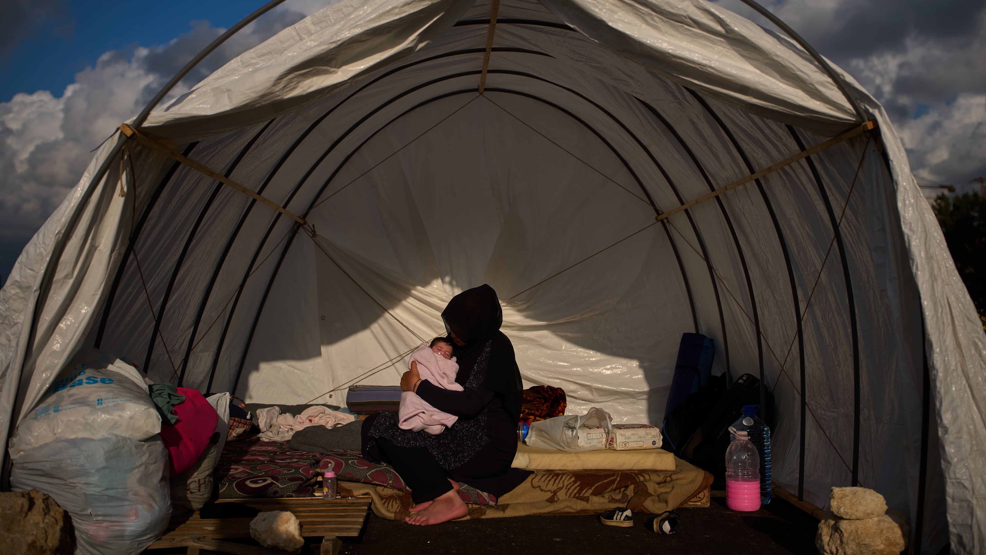 Haifa Kenjo, who fled Israeli airstrikes on the southern suburbs of Beirut, holds her 15-day-old daughter Shiman inside the tent she uses as a shelter and where she gave birth to her in Beirut, Sunday, April 12, 2026. (AP Photo/Emilio Morenatti)