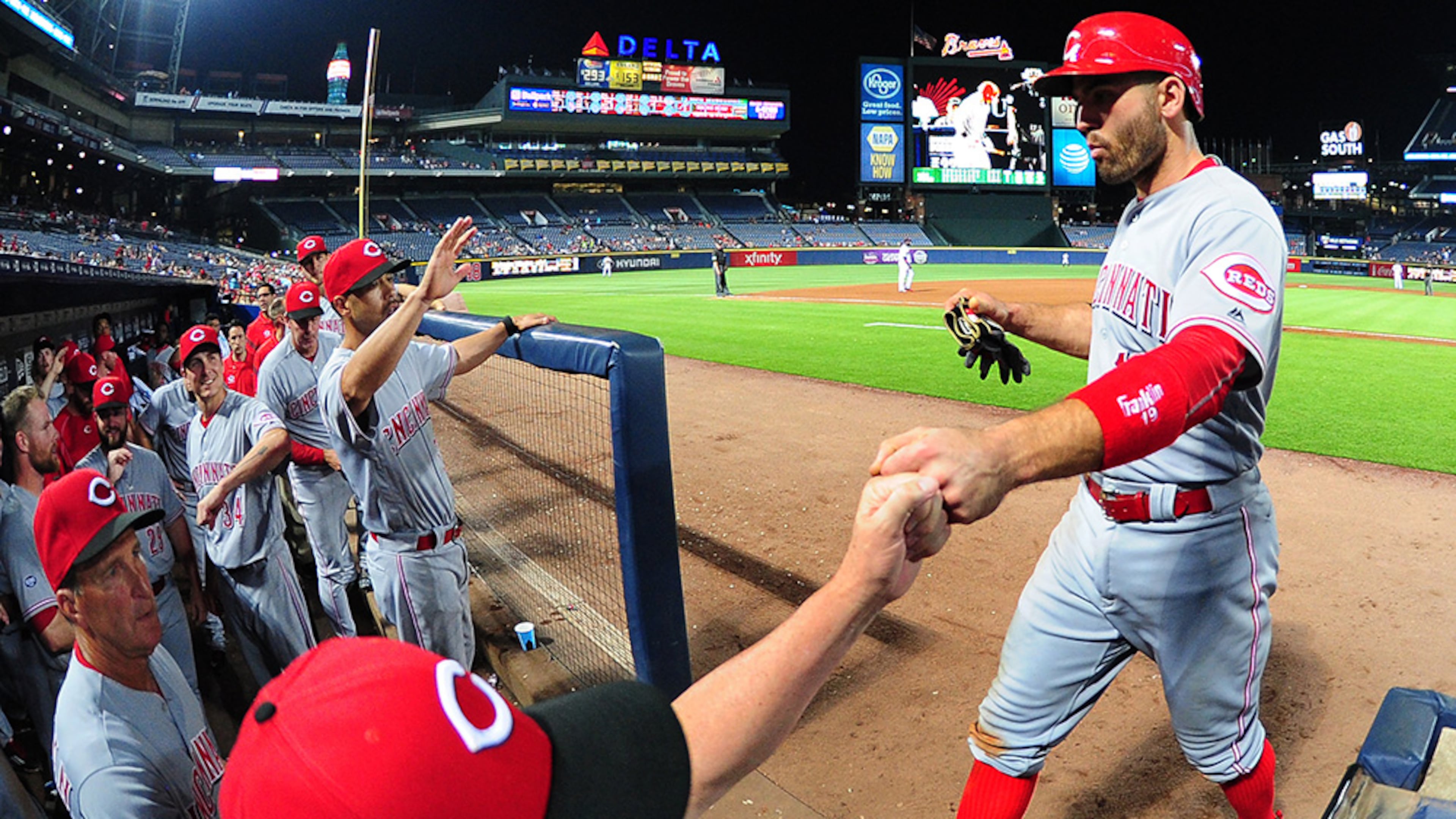The Reds' Joey Votto is congratulated by teammates after scoring on a ninth inning bases loaded walk against the Braves Monday, June 13, 2016, at Turner Field in Atlanta.