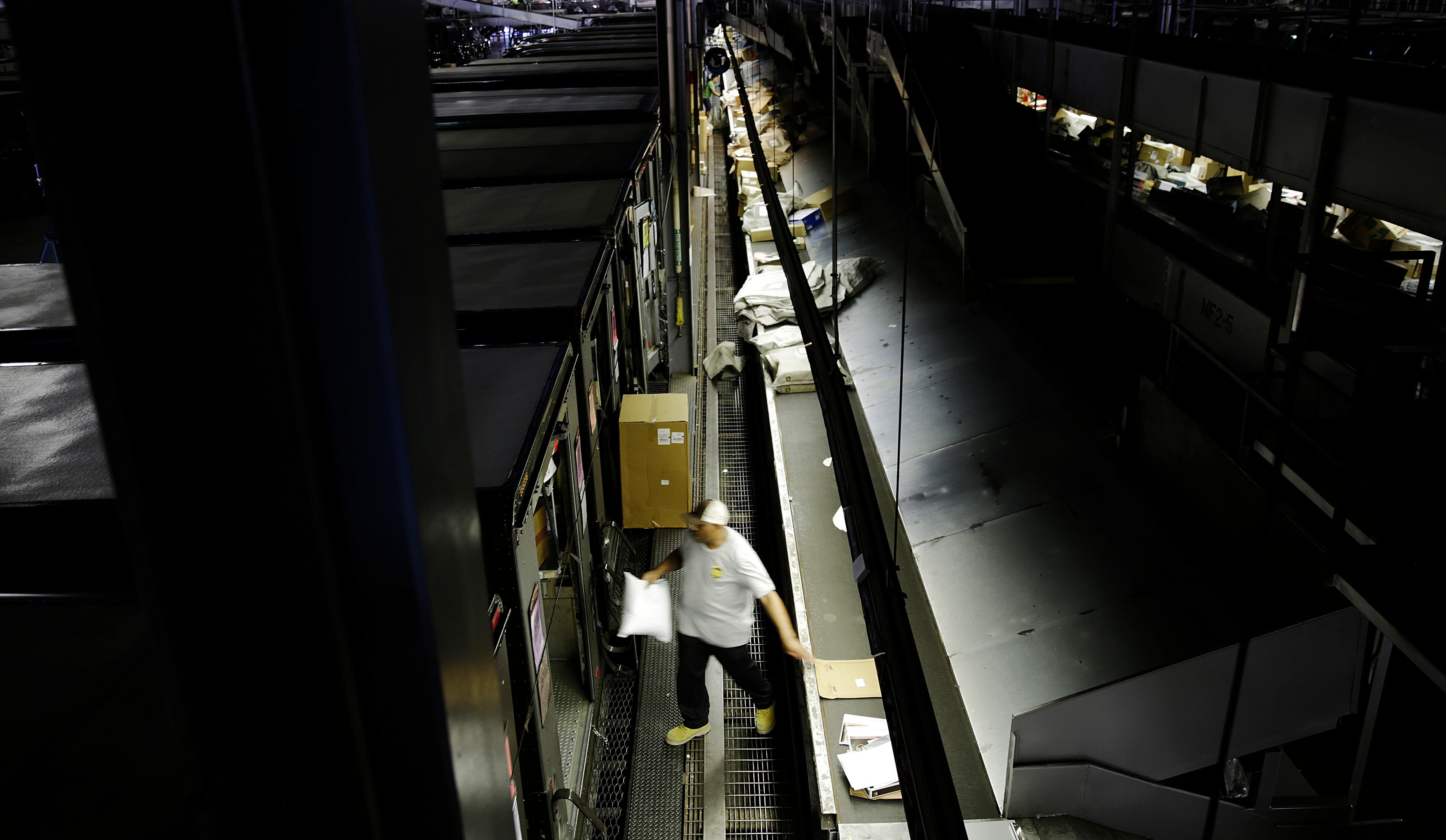 In this June 20, 2014 photo, United Parcel Service pre-loader Etonka Bowden, sorts packages before morning deliveries from the company's sorting facility in Roswell, Ga. (AP Photo/David Goldman)