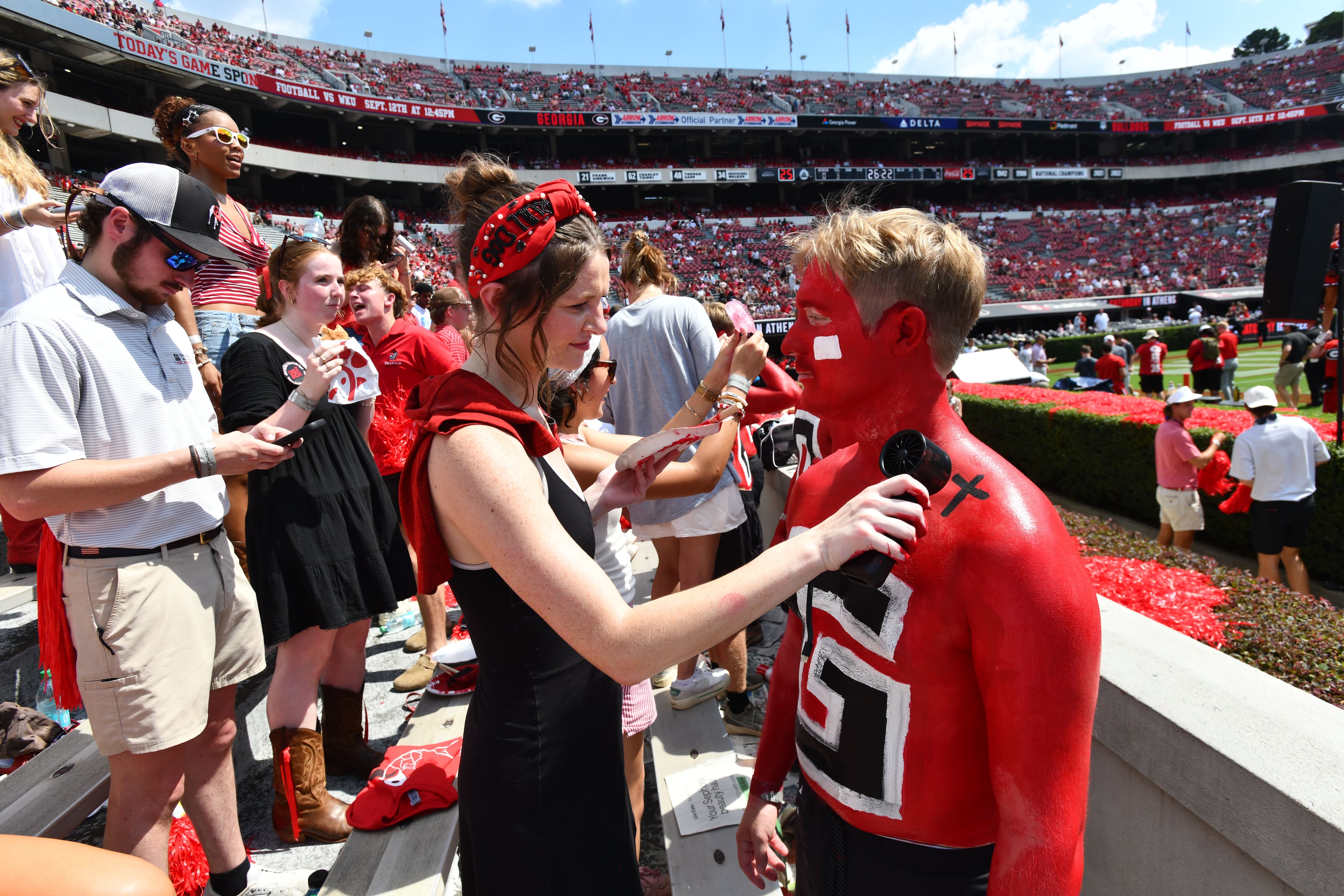 Members of UGA Paint Line cool down with handheld battery-operated fans before Georgia hosts Tennessee State in their season opener at Sanford Stadium on Saturday, Sept. 5, 2026, in Athens, Ga. (Hyosub Shin/AJC)