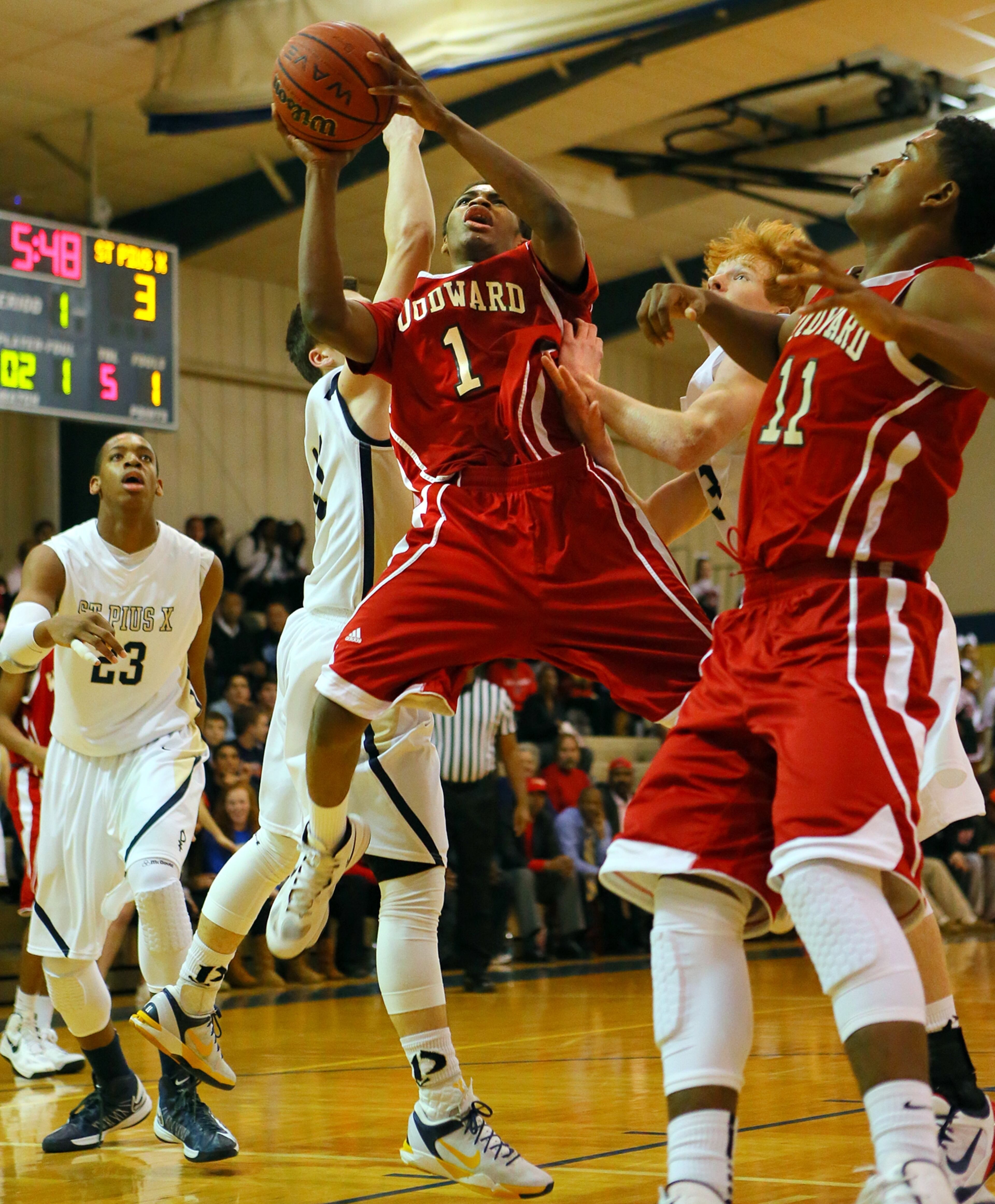 Woodward's Corey Hicks gets off a shot with a trio of St. Pius players defending.