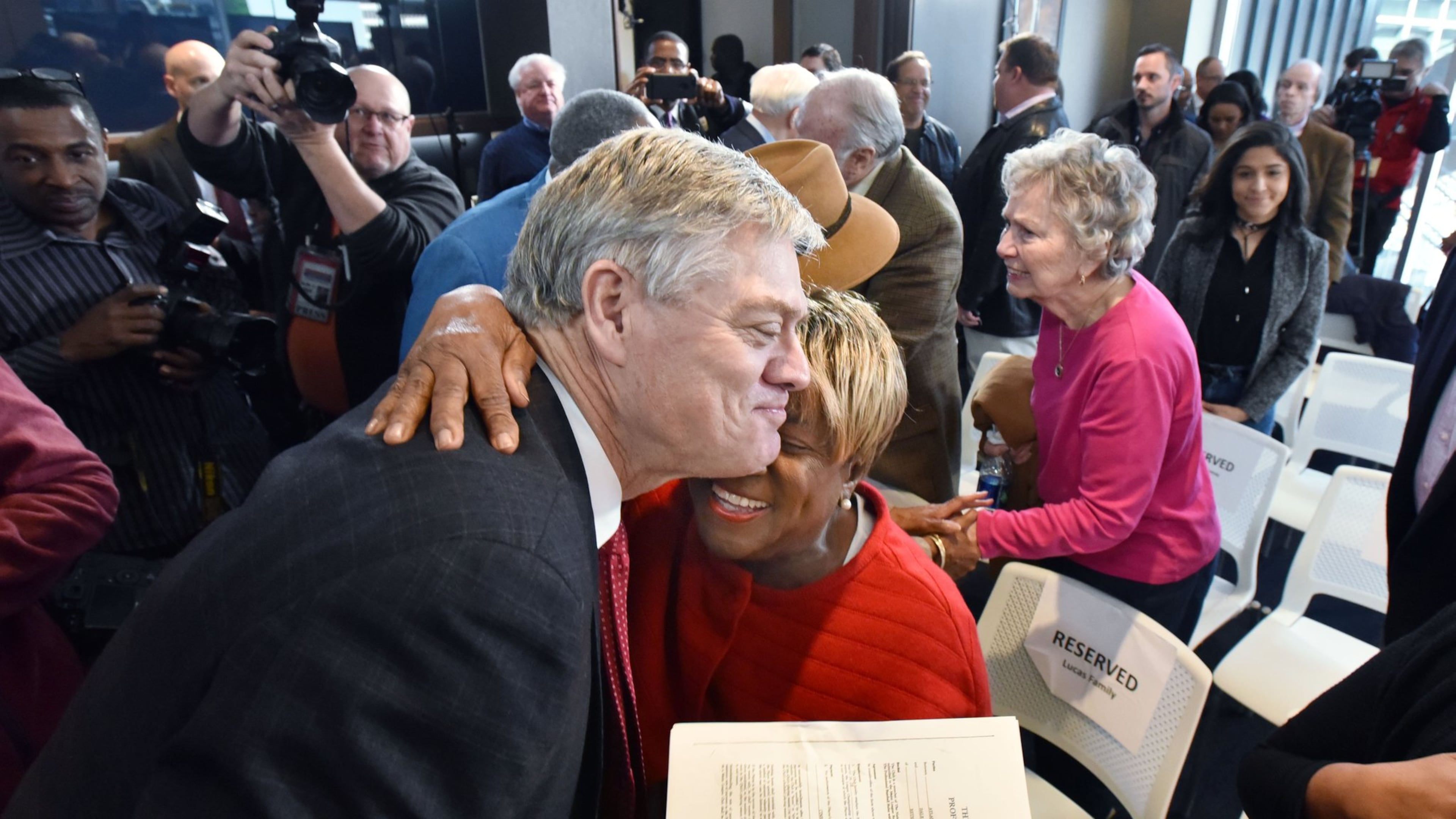 Rubye Lucas, wife of the late Bill Lucas, hugs former Braves star Dale Murphy on Thursday as he holds a copy of his 1978 contract, signed by Lucas. HYOSUB SHIN / HSHIN@AJC.COM