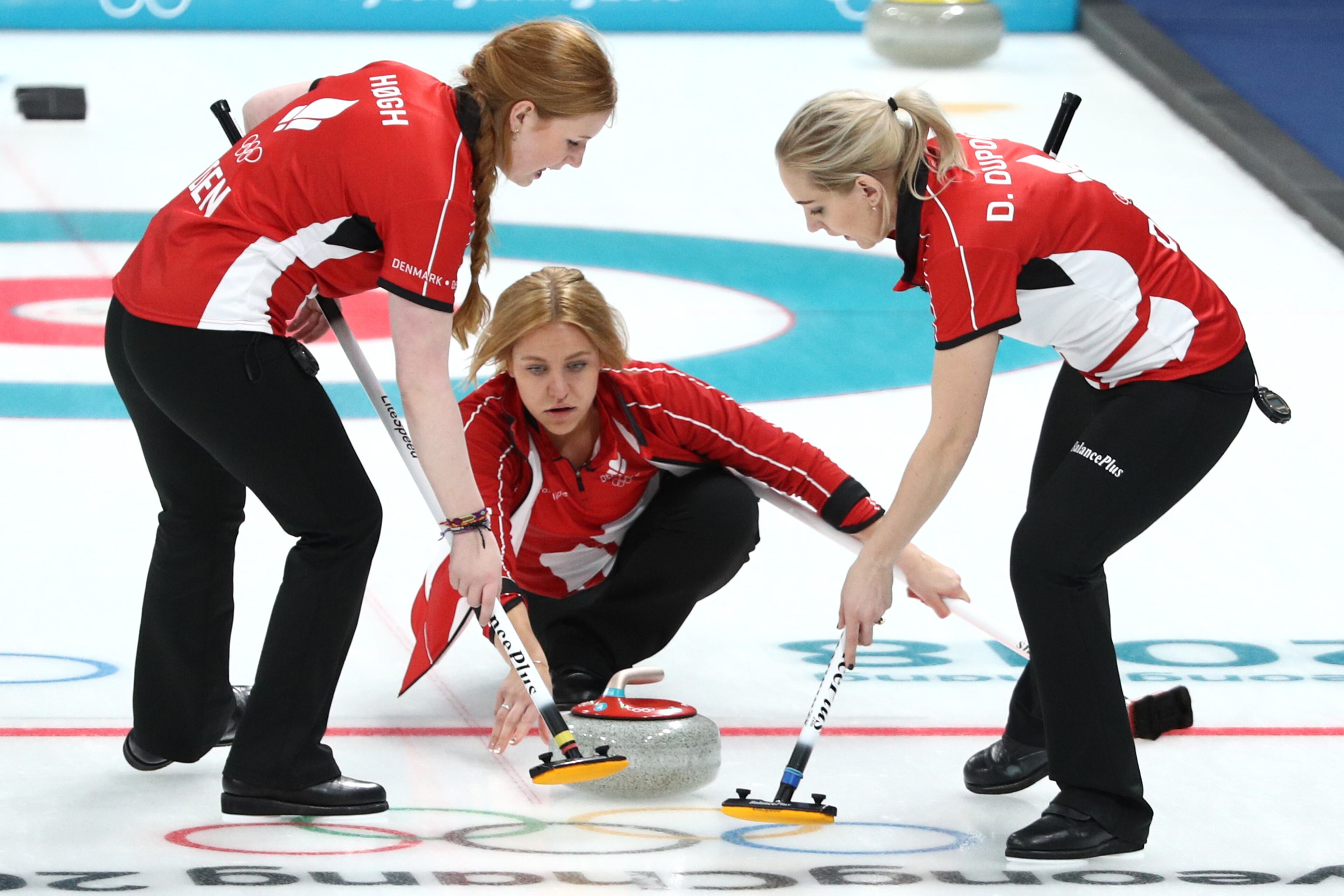 GANGNEUNG, SOUTH KOREA - FEBRUARY 16: Madeleine Dupont delivers a stone between Julie Hogh and Denise Dupont of Denmark during the Curling Women's Round Robin Session 4 at Gangneung Curling Centre on February 16, 2018 in Gangneung, South Korea.(Photo by Maddie Meyer/Getty Images)