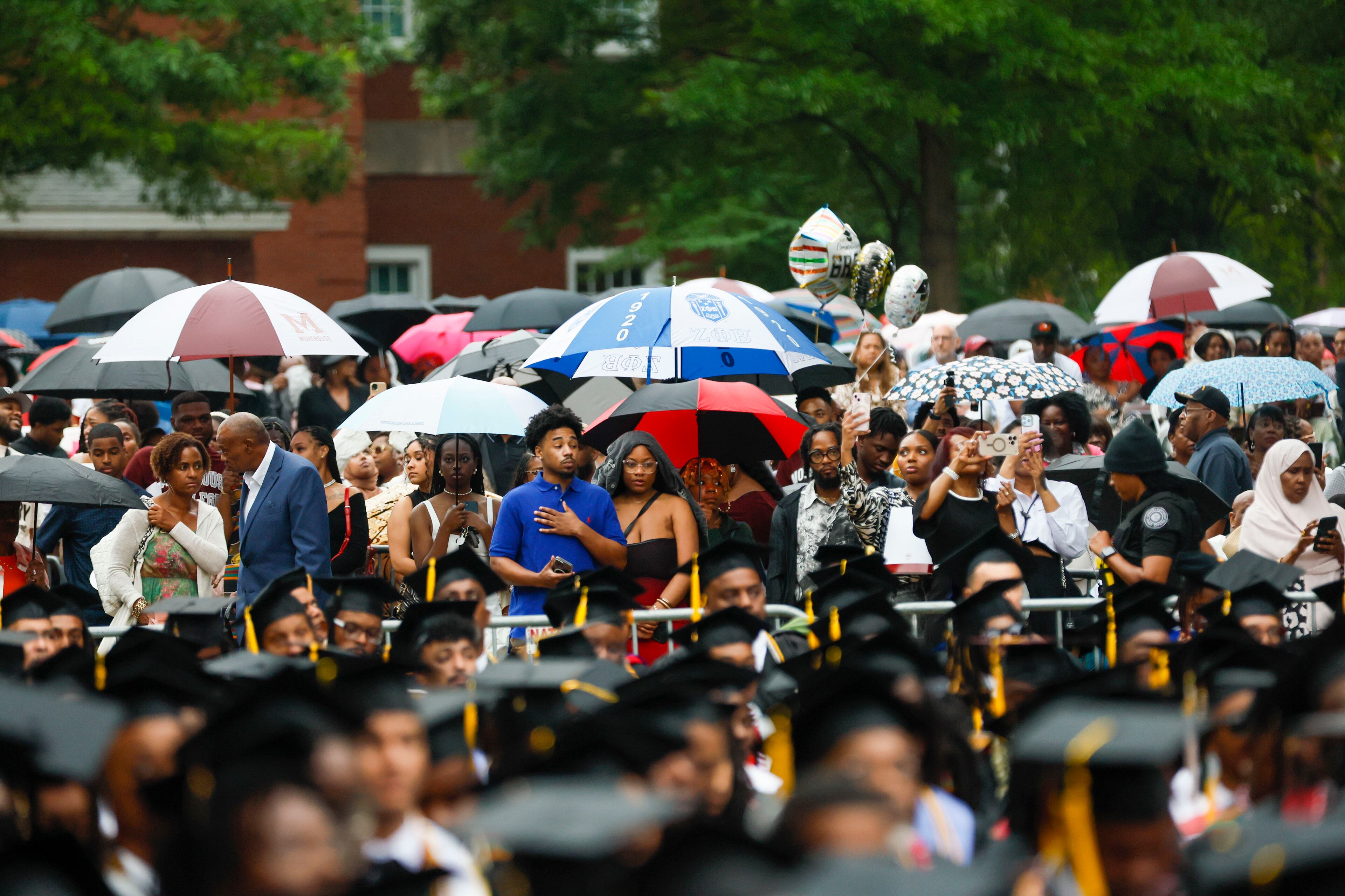 Family members cover themselves with umbrellas as rain starts to fall during Morehouse College's 141st Commencement Ceremony on Sunday, May 18, 2025.
(Miguel Martinez/ AJC)