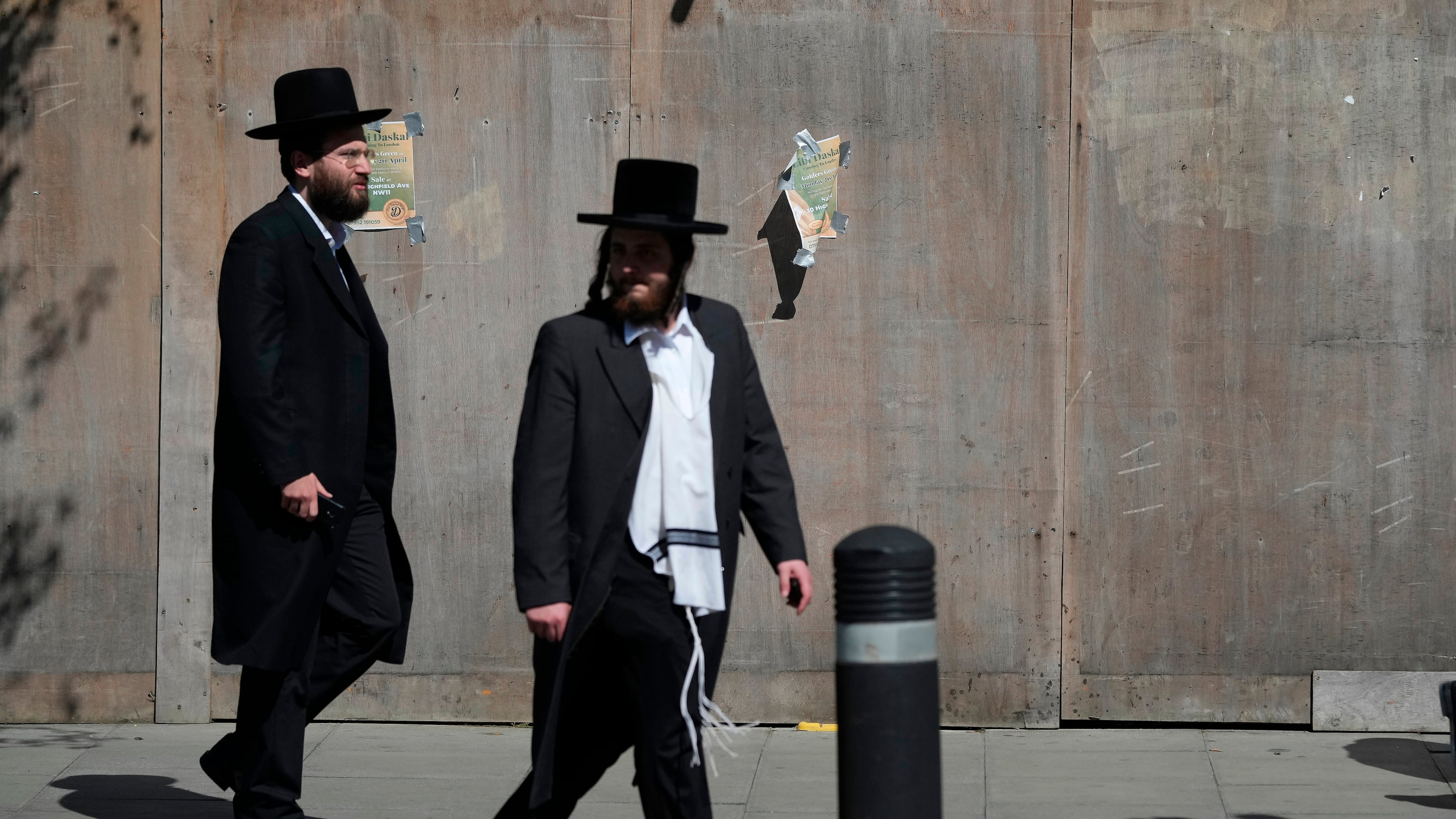 Two men walk in London, Thursday, April 30, 2026, near the scene where two people were recently stabbed in the Golders Green neighbourhood, that has a large Jewish community. (AP Photo/Alastair Grant)