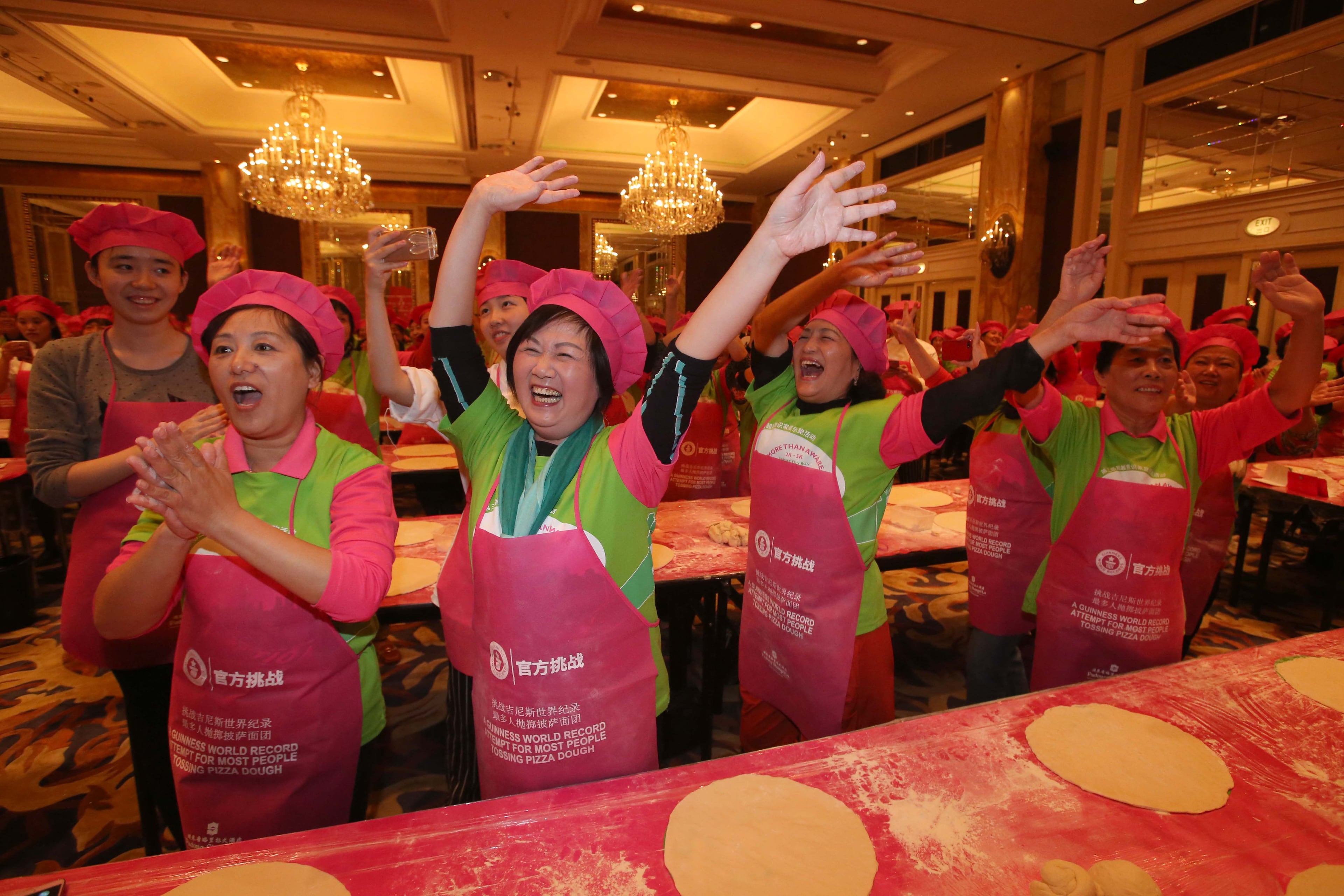 Guinness World Record for the most people tossing pizza dough - SHANGHAI, CHINA - OCTOBER 28: (CHINA OUT) Participants take part in tossing pizza dough as they officially break the Guinness World Record for the most people tossing pizza dough at Shanghai Shangri-La Hotel on October 28, 2015 in Shanghai, China. 511 participants completed the attempt and broke the previous Guinness World Record title of 338 people achieved by Papa John's in London in June this year. These pizzas would be sold at a pastry shop with each pizza of 30 RMB after the challenge and all proceeds would be donate to cancer patients as charity contributions. (Photo by ChinaFotoPress/ChinaFotoPress via Getty Images)