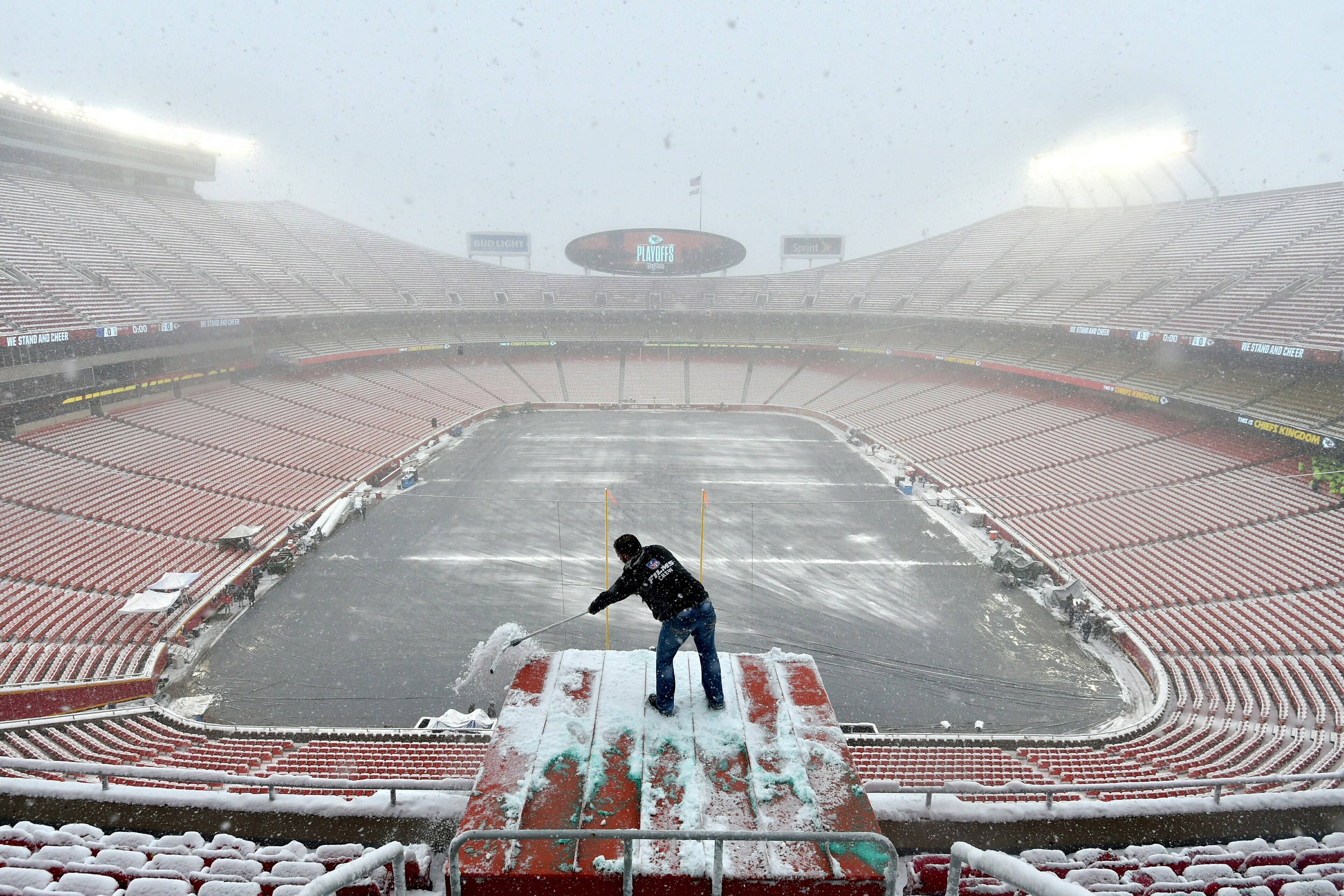 Kyle Haraugh, of NFL Films, clears snow from a camera location at Arrowhead Stadium before an NFL divisional football playoff game between the Kansas City Chiefs and the Indianapolis Colts, in Kansas City, Mo., Saturday, Jan. 12, 2019. (AP Photo/Ed Zurga)