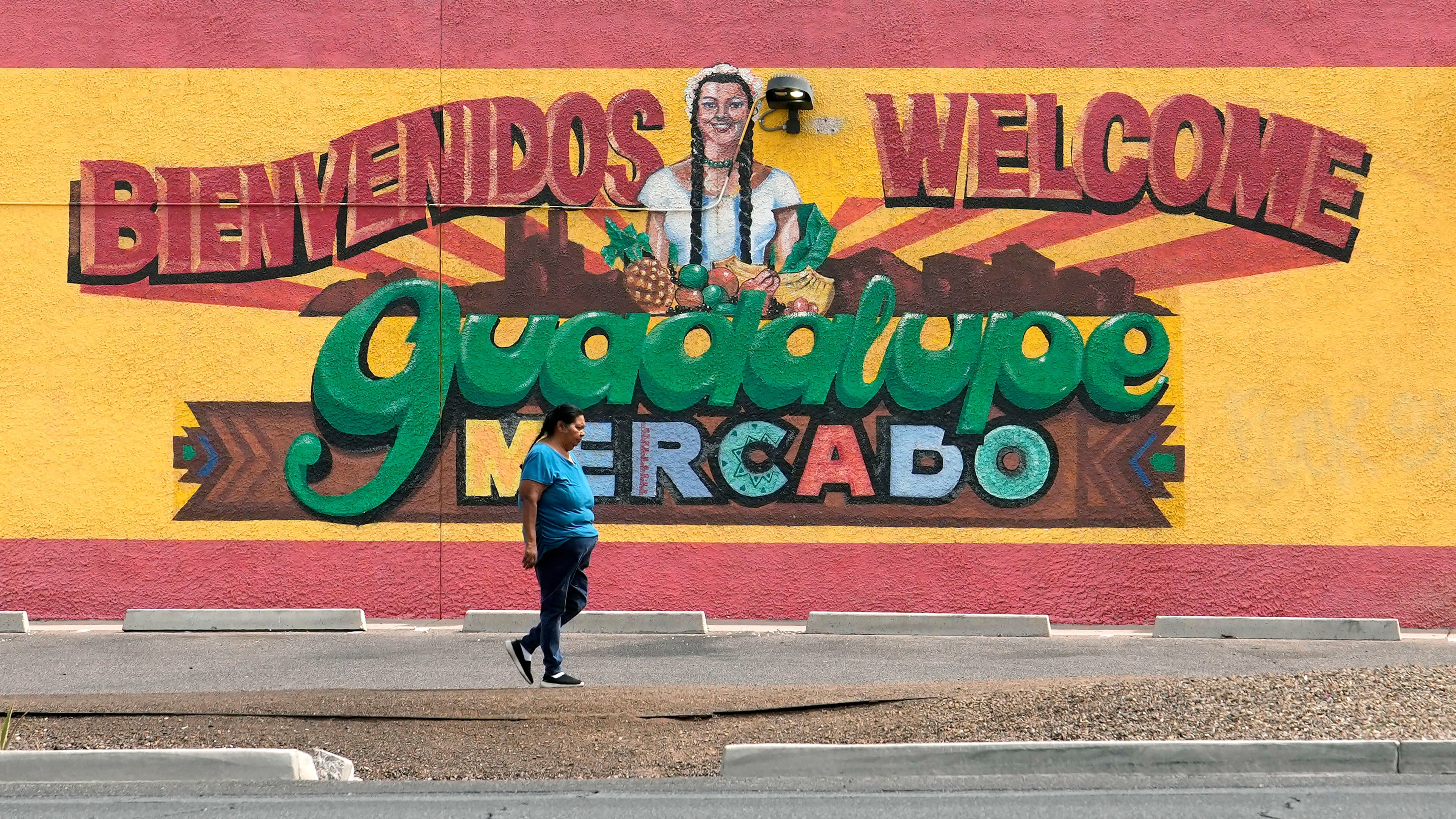 A person walks past a mural promoting Guadalupe, Ariz., May 19, 2026. (AP Photo/Ross D. Franklin)
