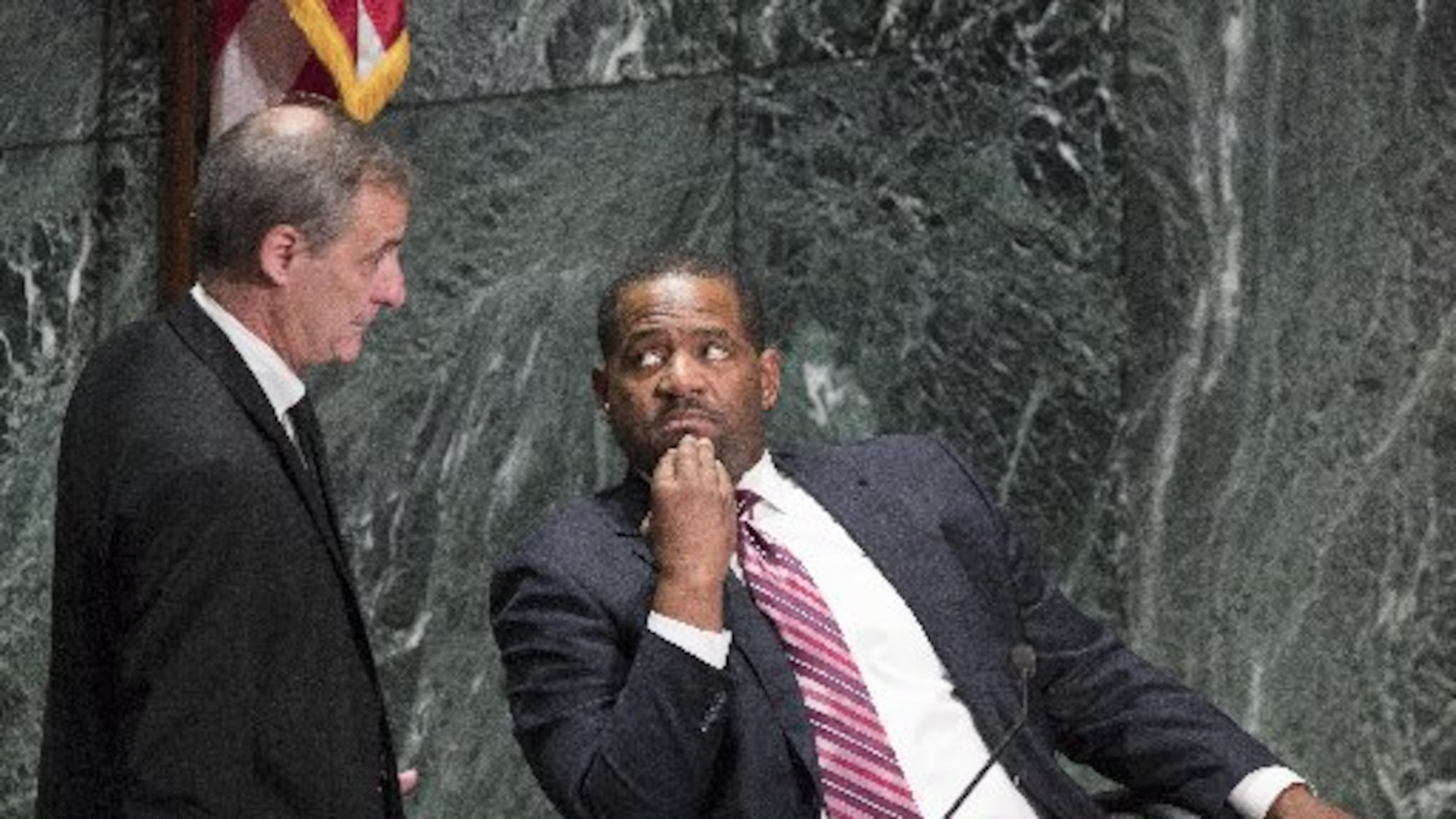 Atlanta Councilman Howard Shook (left) and council president Ceasar Mitchell confer during the Dec. 4 city council meeting, at which 288 employees were approved to buy back in to the city’s defined benefit pension system.