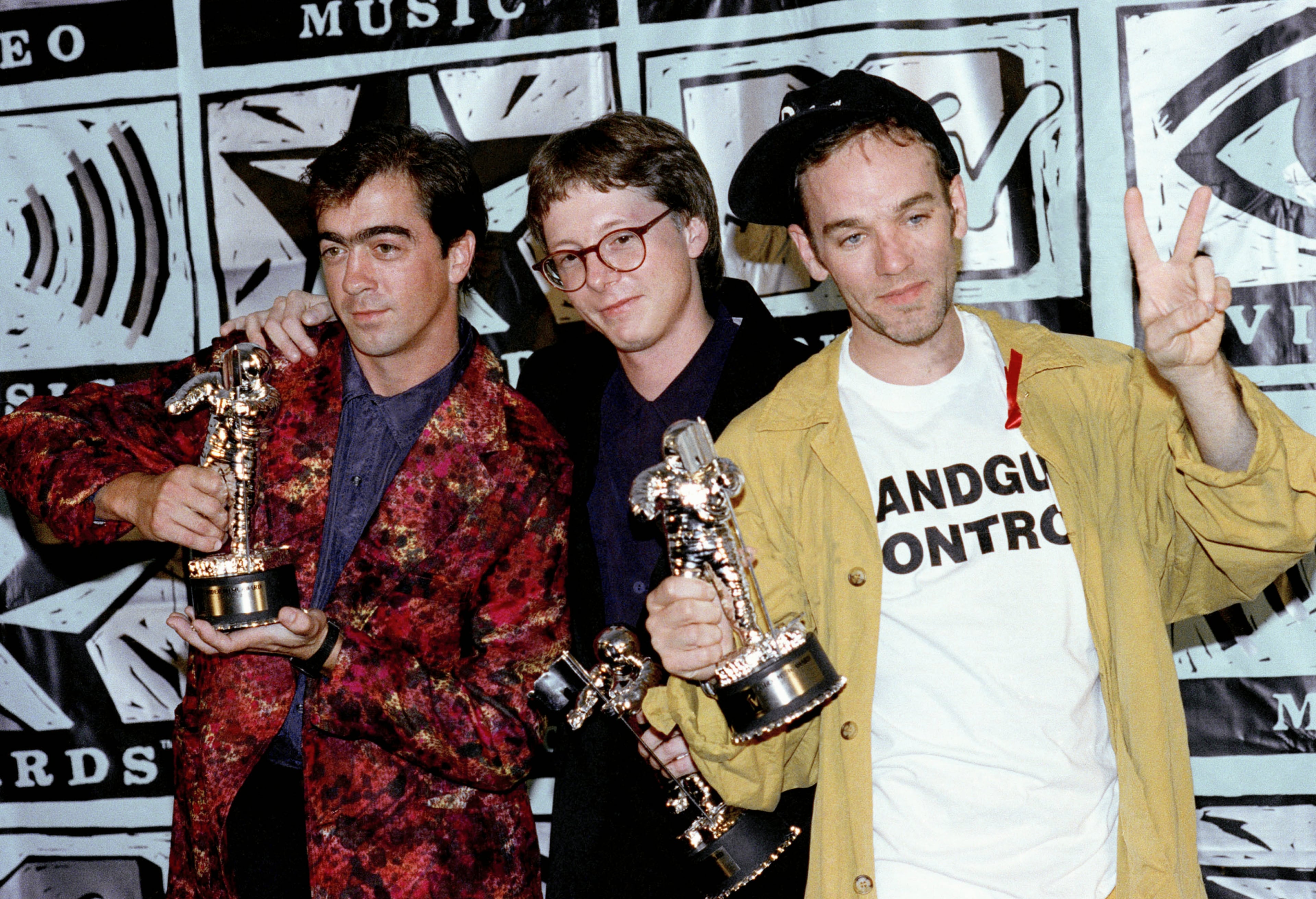 Members of the music group R.E.M, from left, Bill Berry, Mike Mills and Michael Stipe, pose with MTV Video Music Award statuettes after winning in six categories at the award show in Universal City, Calif., Sept. 6, 1991. The group won Video of the Year, Best Group, Best Direction, Best Art Direction, Best Editing and Breakthrough Video of the Year. Missing from the group is guitarist Peter Buck.