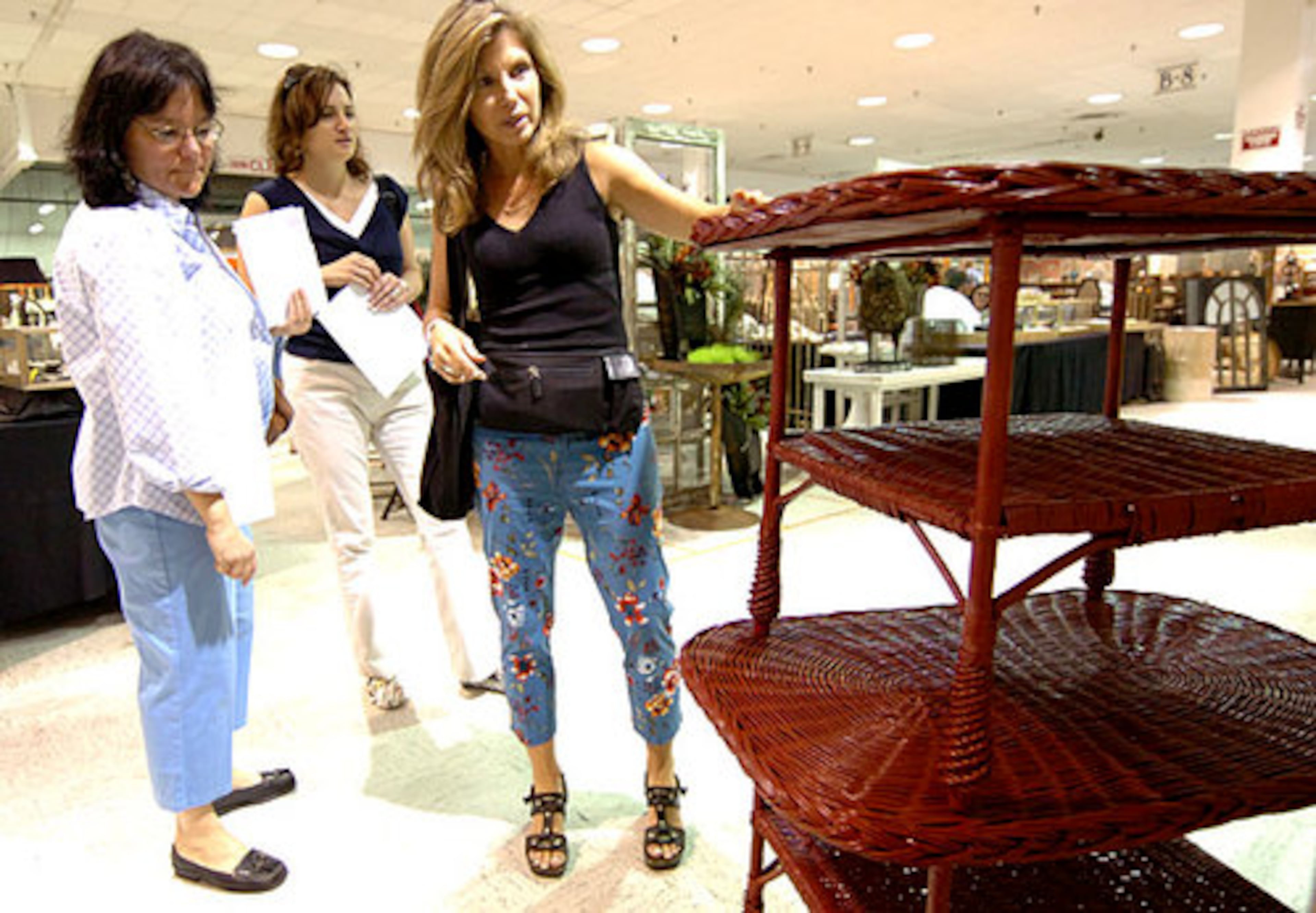 Laura Iarocci (left) and Roula Elias (center) check out tables with Christine Eisner. The antiques market, which features more than 2,400 vendors, can be an overwhelming shopping experience for first-timers. Eisner leads groups through the market at least six times a year to help them out.