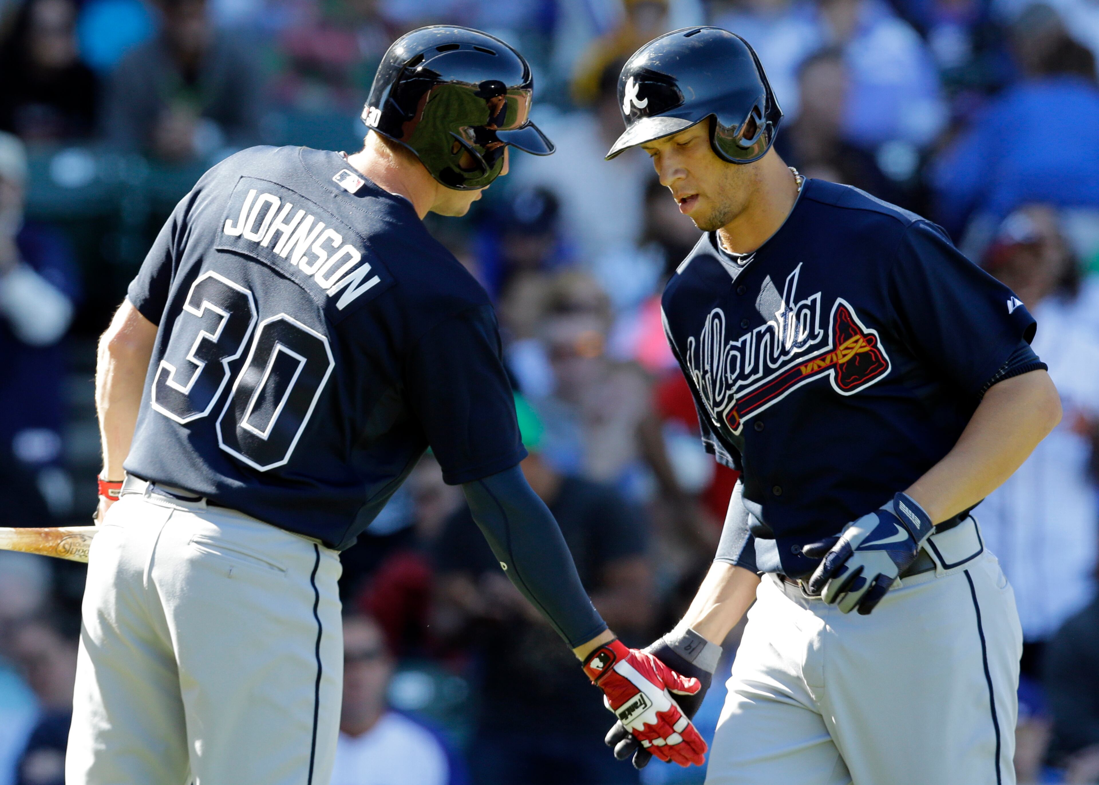 Atlanta Braves' Andrelton Simmons, right, celebrates with Elliot Johnson after hitting a solo home run against the Chicago Cubs.