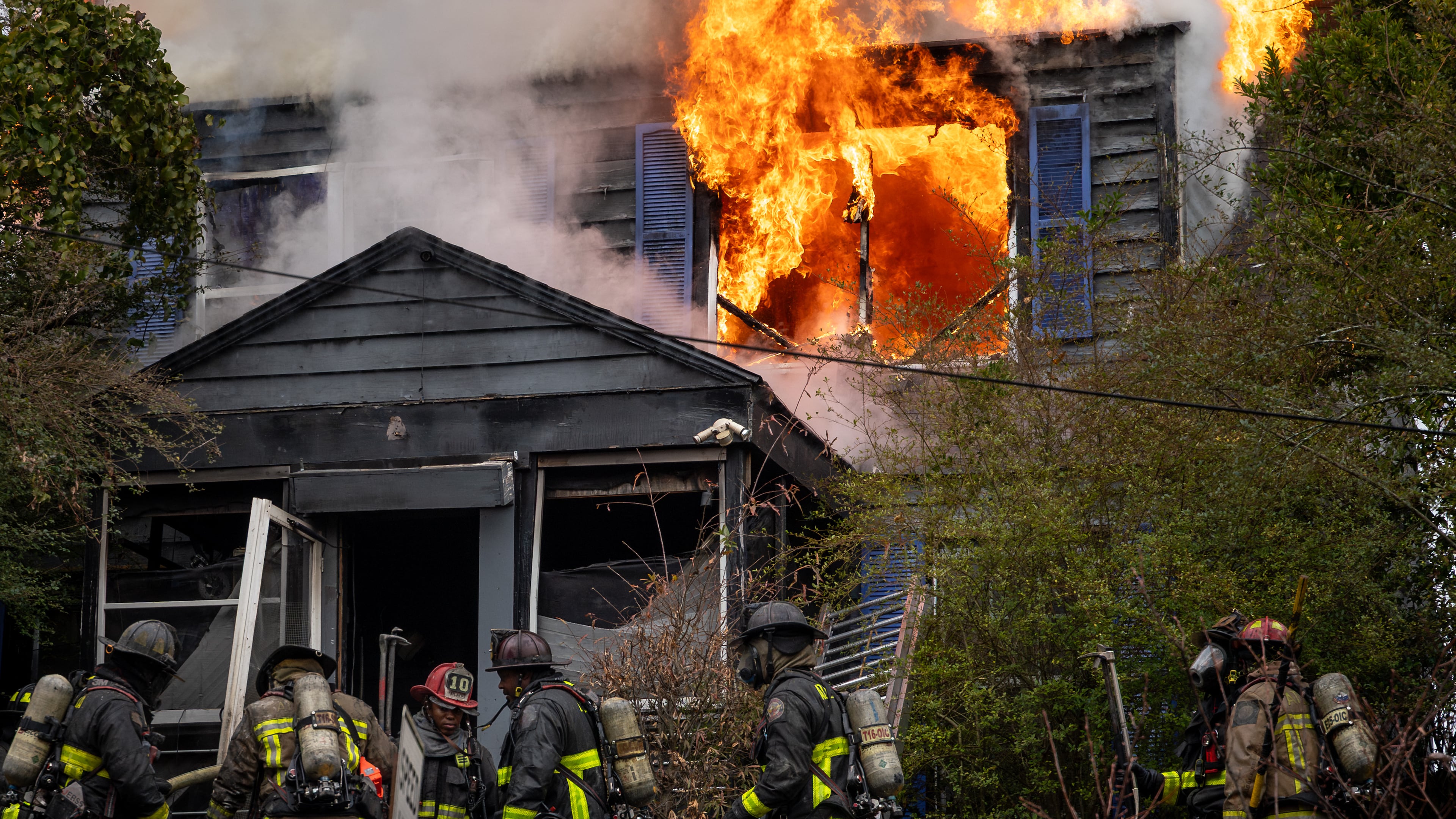 Atlanta firefighters battle a blaze at a home on Fair Street in southwest Atlanta late last year. The former head of the city's firefighter union is suing the city, the mayor and fire chief, alleging retaliation against him for advocating for better working conditions. (Ben Hendren for the AJC)
