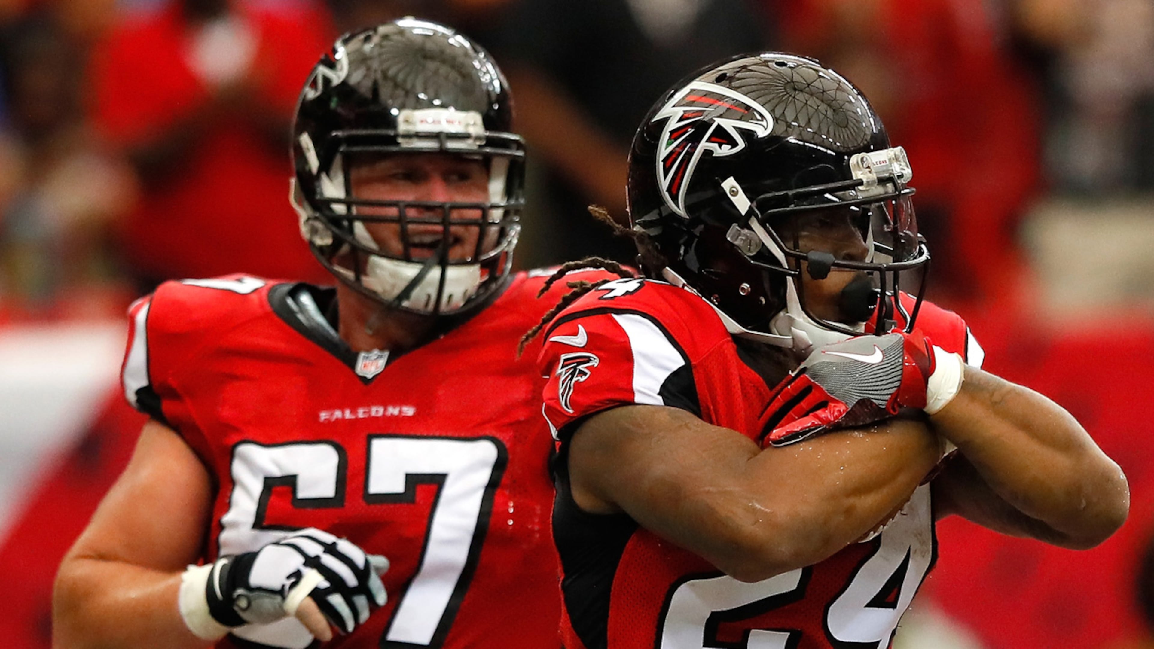 Devonta Freeman (right) of the Atlanta Falcons reacts with Andy Levitre after scoring a touchdown against the Carolina Panthers at Georgia Dome on October 2, 2016 in Atlanta, Georgia.