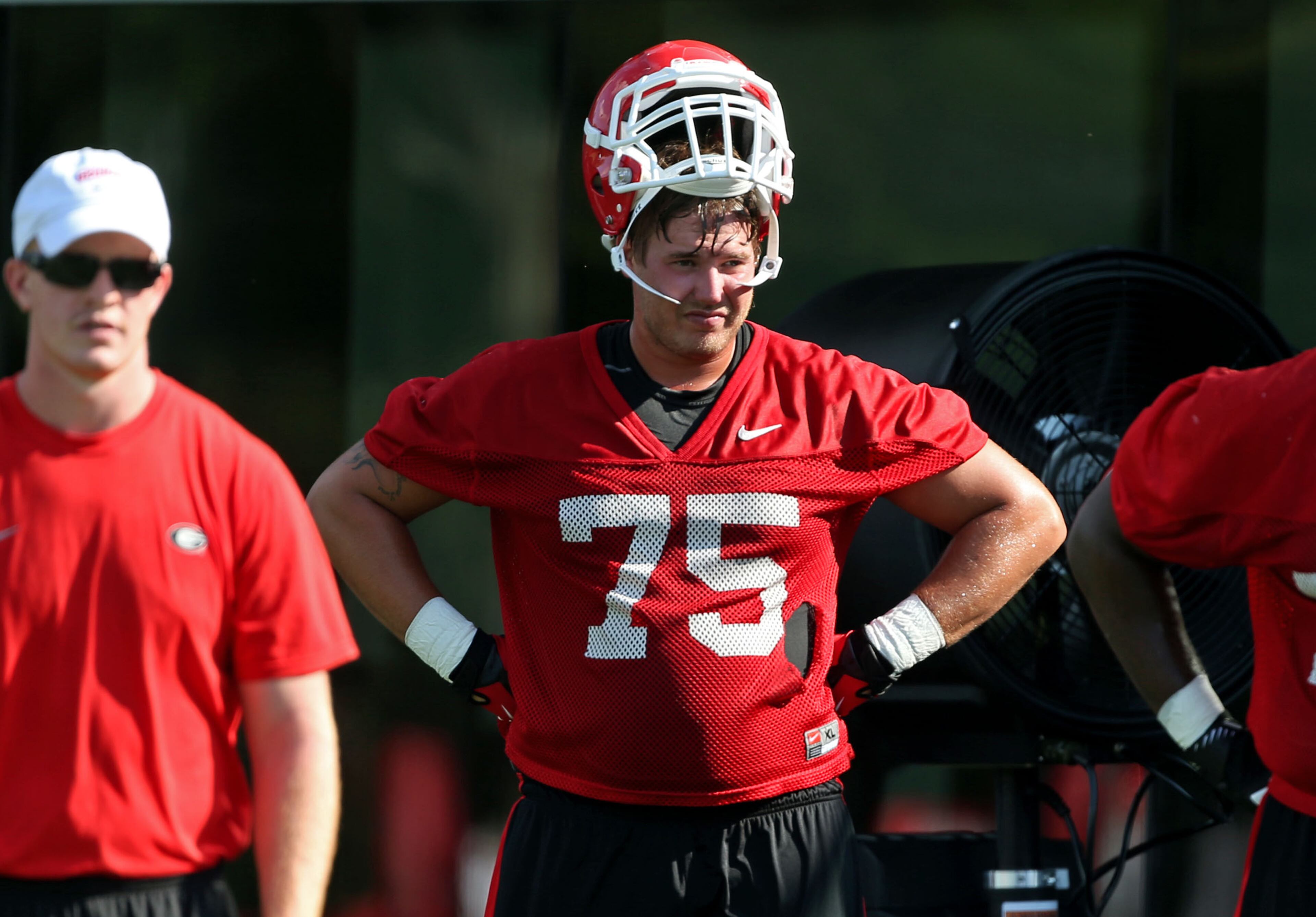 University of Georgia offensive lineman Kolton Houston (75) takes a break during practices on the first day of practice at the University of Georgia Thursday afternoon in Athens, Ga., August 1, 2013. This is the first practice that Houston is now eligible to play in games. Houston, now a junior, was declared ineligible to participate by the NCAA soon after arriving on campus as a midyear freshman enrollee in January of 2010. JASON GETZ / JGETZ@AJC.COM