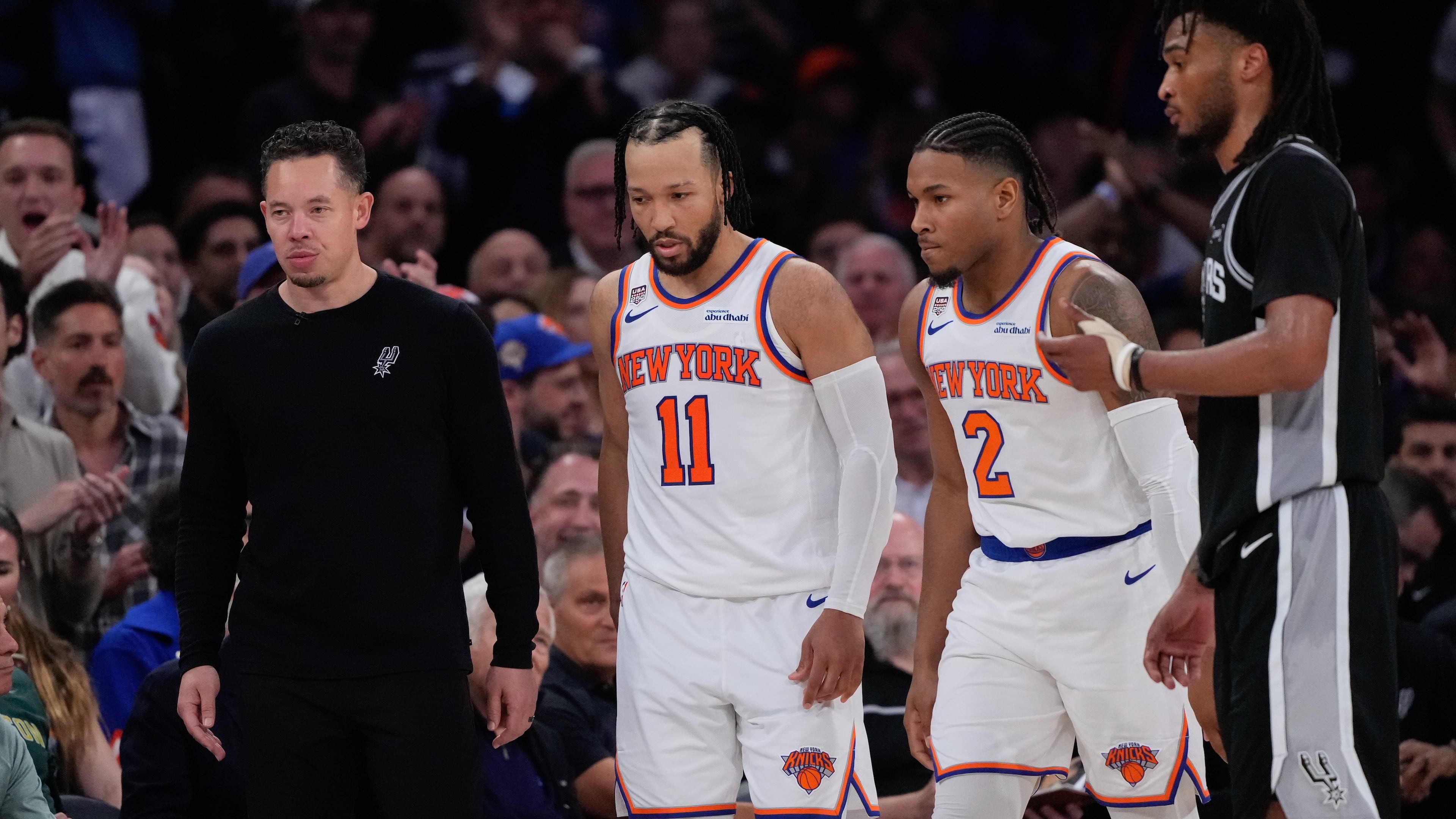New York Knicks guard Jalen Brunson (11) and guard Miles McBride (2) walk to their bench as San Antonio Spurs head coach Mitch Johnson, left, looks away during second half of Game 3 of the NBA Finals basketball series, Monday, June 8, 2026, in New York. (AP Photo/Ross D. Franklin)