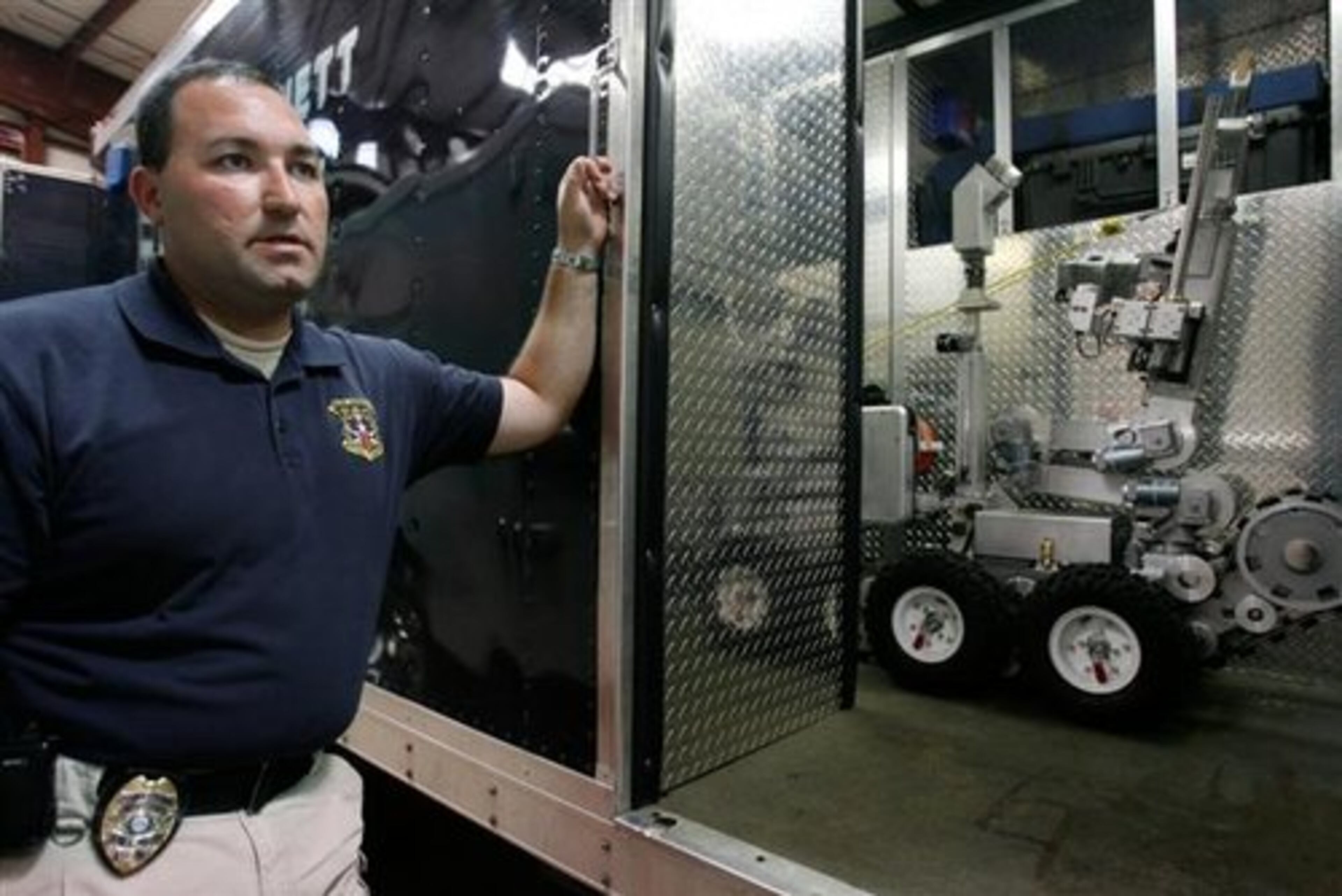 The robot (at right mounted on the truck) is rather small. Here, Gwinnett Police SWAT Team bomb squad technician officer Kevin Moller explains how robots aid law enforcement work.