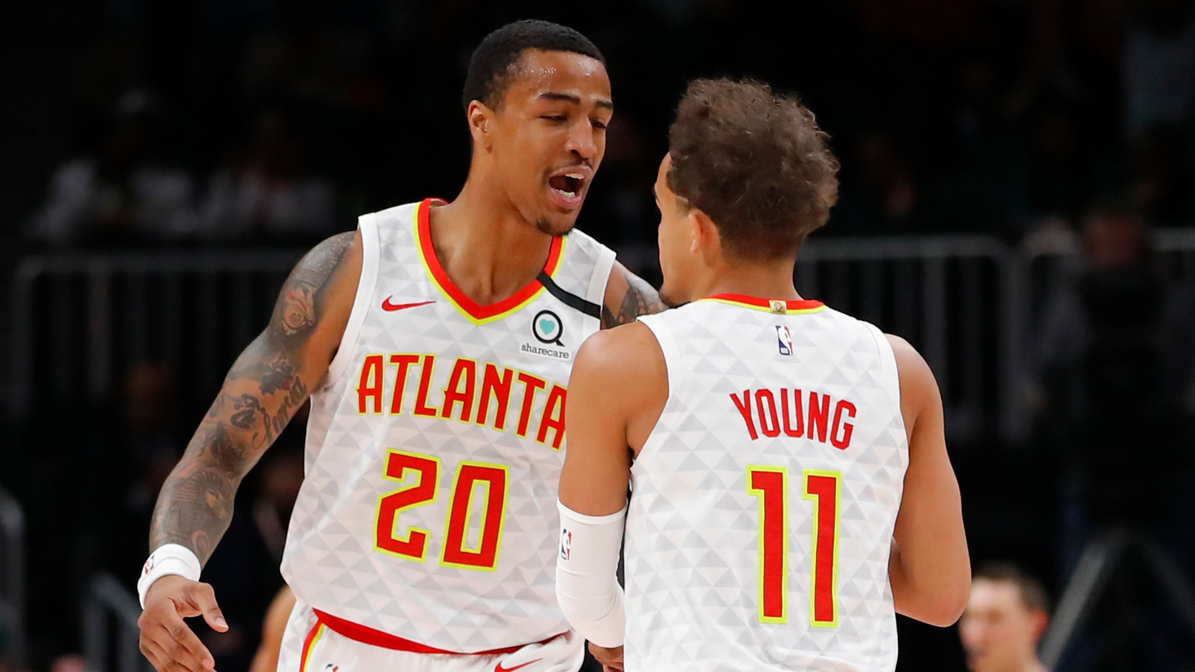 Hawks forward John Collins (20) reacts with guard Trae Young (11) in the first half of an NBA basketball game against the Boston Celtics on Monday, Feb. 3, 2020, in Atlanta. (AP Photo/Todd Kirkland)