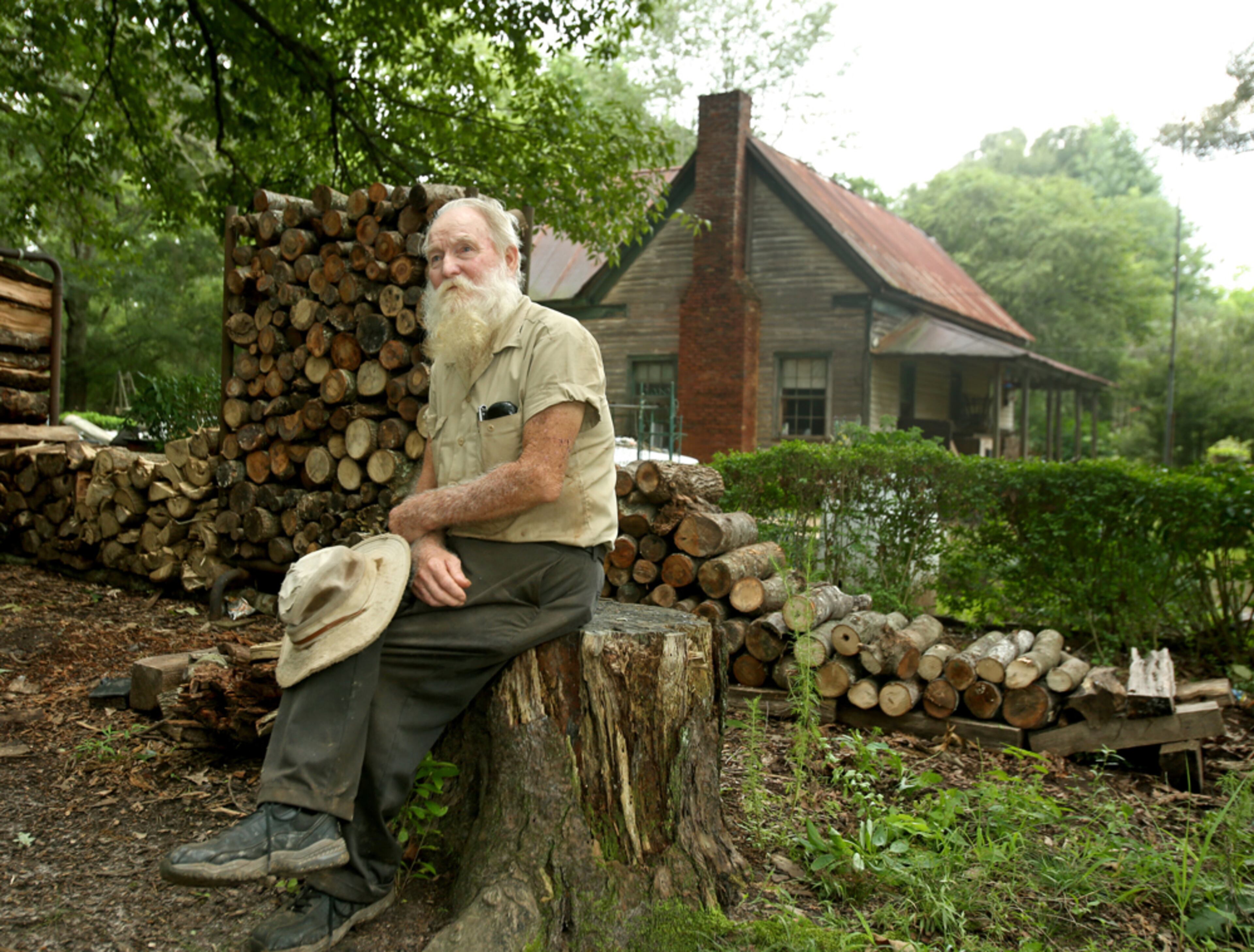 PRINT PRIORITY. August 14, 2013 - Ball Ground, Ga: 76-year-old Edward Parker has lived at his family's property all his life shown Wednesday afternoon in Ball Ground, Ga., August 14, 2013. Parker lives in a 100 year-old house built by his grandfather in 1913. Parker lives simply, without gas, cooking on a wood stove top and heating his home with a wood fireplace. Getz said, "I was doing a story on the potential of a subdivision coming into the area where Mr.Parker lived and I had no idea what I would find. I found a scene that's frozen in time. Had it not been for Mr. Parker's sneakers, this photograph could have been taken in the 1950s. That day I enjoyed visiting with Mr. Parker talking about a simpler time, cars, and dogs." JASON GETZ / JGETZ@AJC.COM