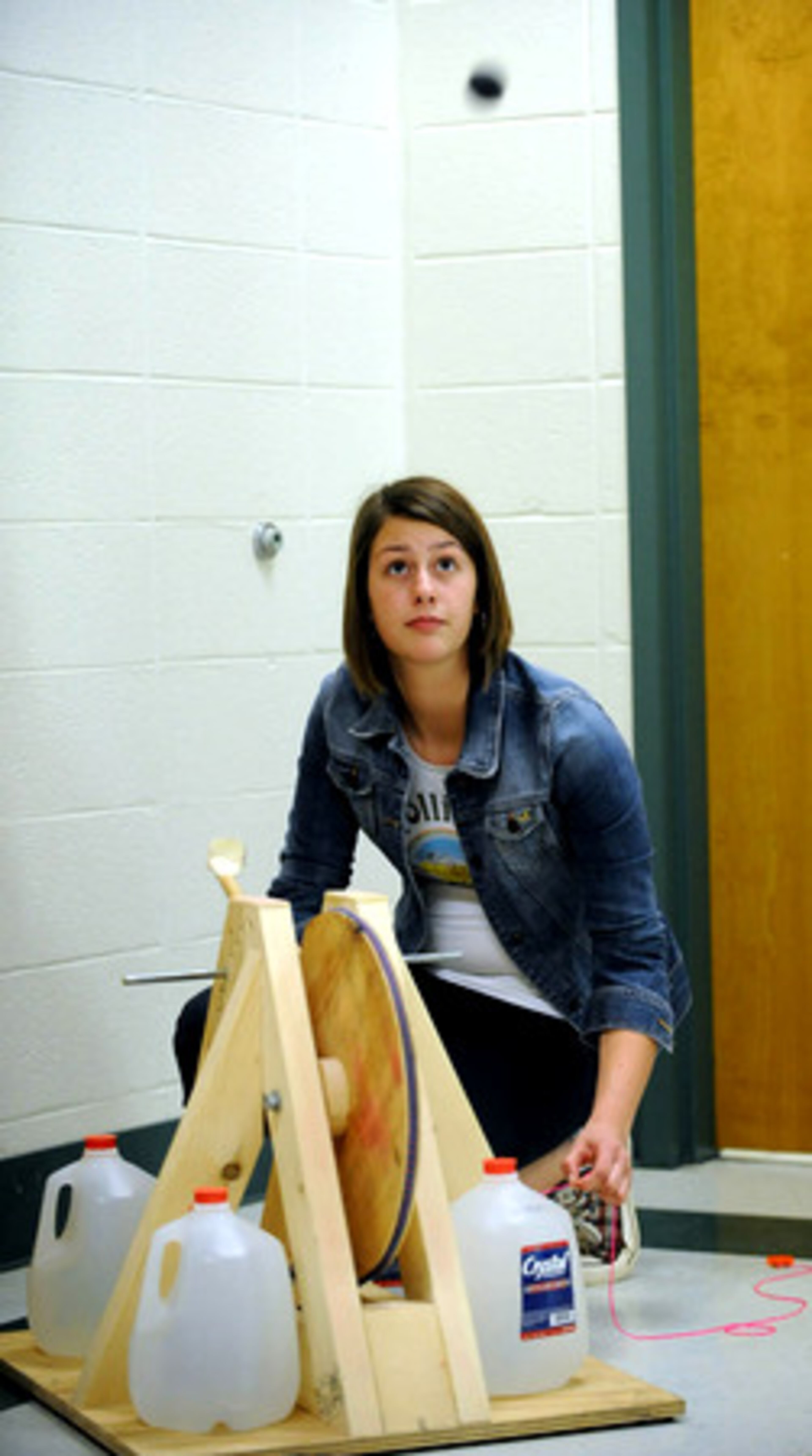 Ninth-grader Cara Ludwick works on her trajectory test at J.C. Booth Middle School on Thursday afternoon. Trajectory is the name of the event in which students use an elastic powered machine to hit targets.