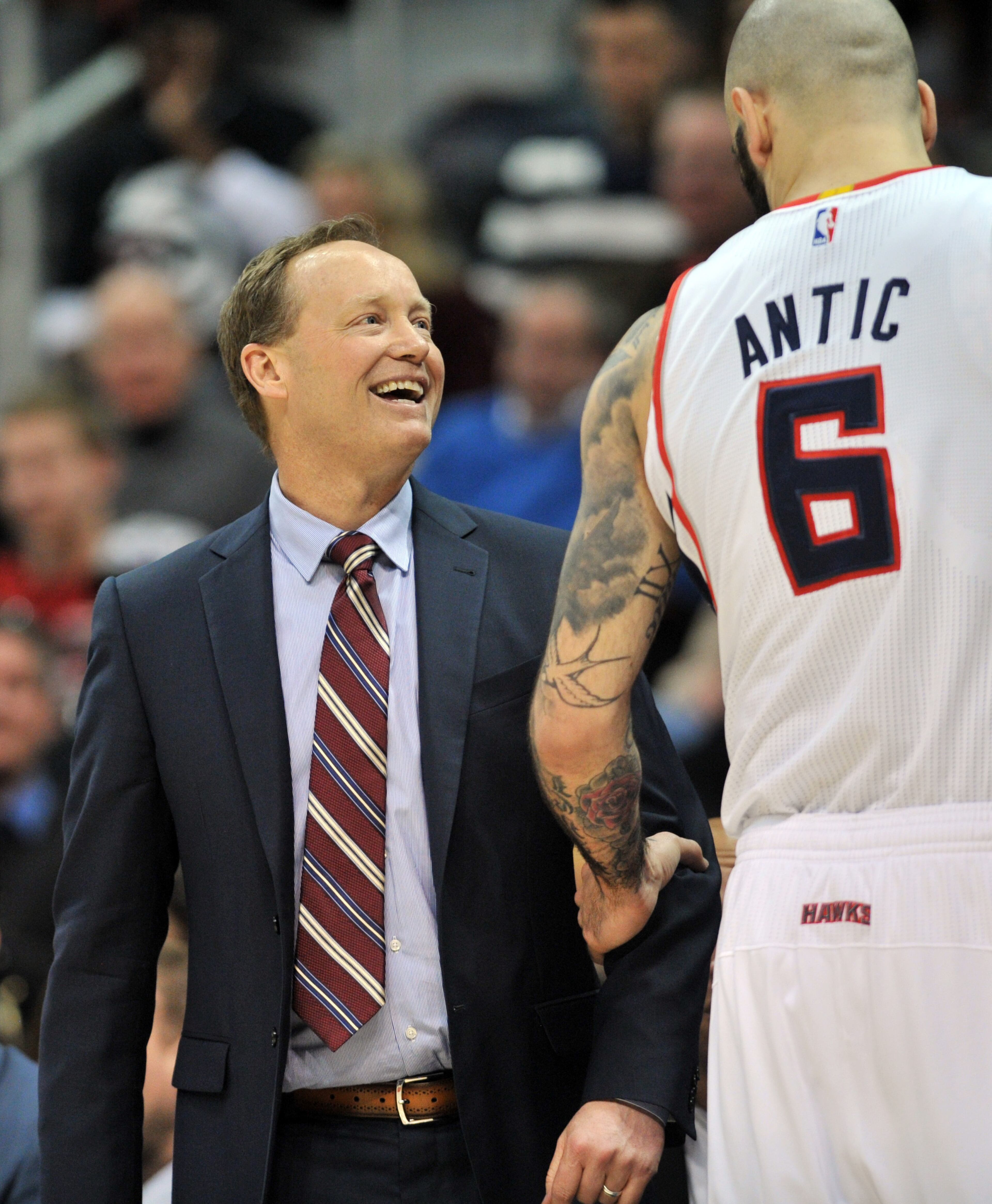 Hawks head coach Mike Budenholzer smiles as he speaks to forward Pero Antic on Wednesday, February 25, 2015. HYOSUB SHIN / HSHIN@AJC.COM