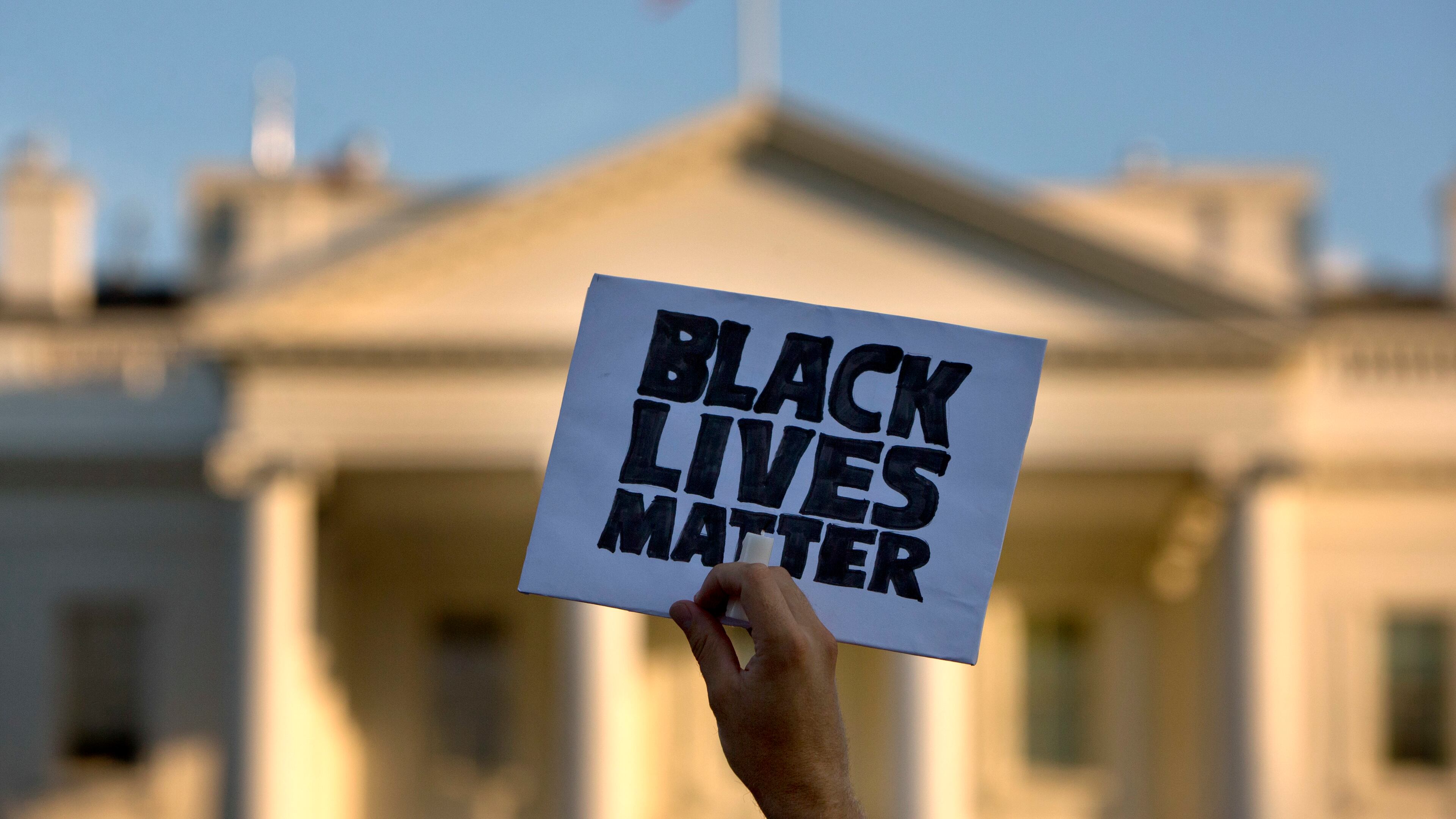 In this July 8, 2016, photo, a man holds up a sign saying "black lives matter" during a protest of shootings by police, in Washington by the White House. (AP Photo/Jacquelyn Martin)