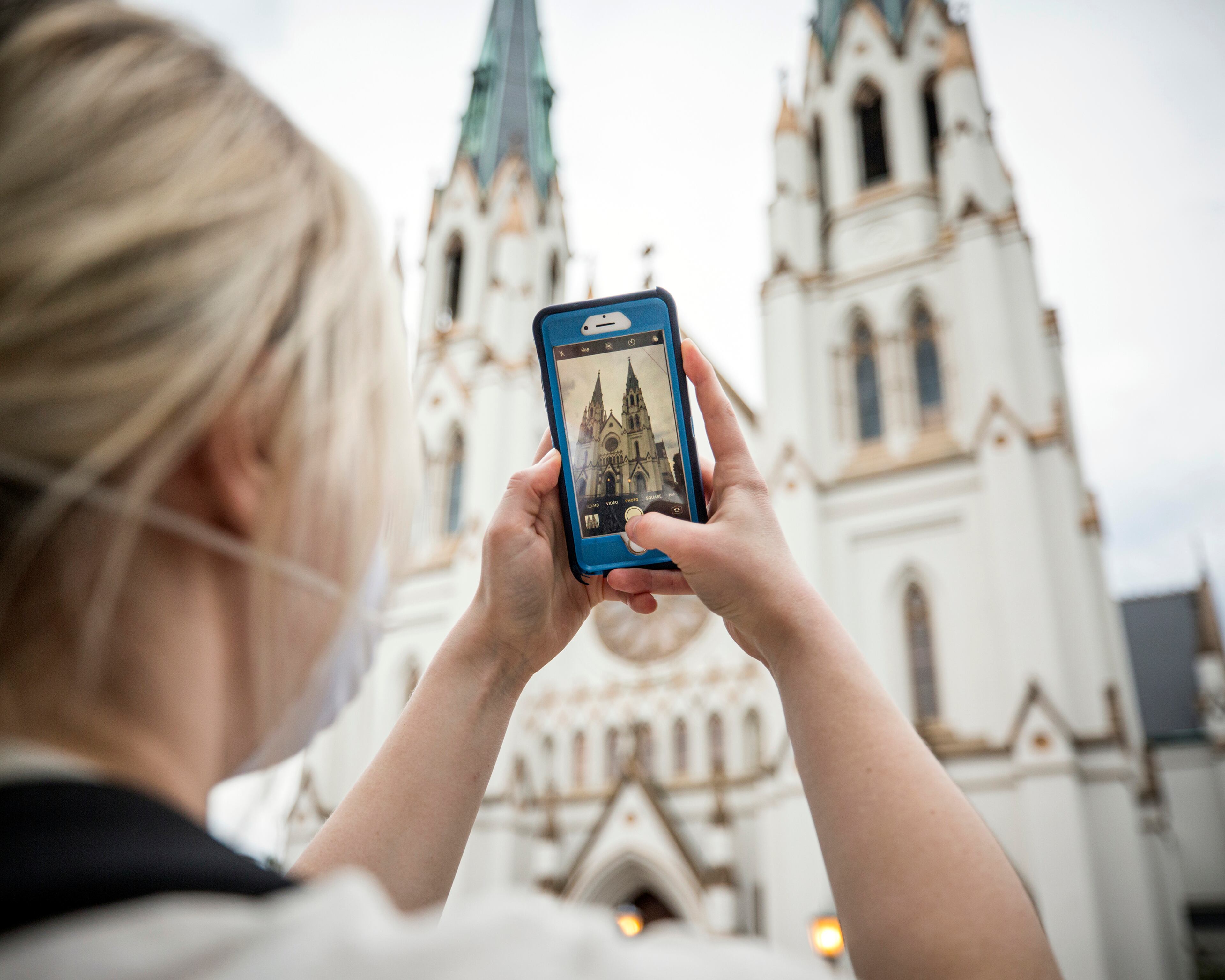 SAVANNAH, GA - APRIL 7, 2020: Savannah College of Art and Design student Emmy Kidman uses her cell phone to take a photo of the Cathedral of St. John the Baptist for an online class project. (Stephen B. Morton for The Atlanta Journal-Constitution)