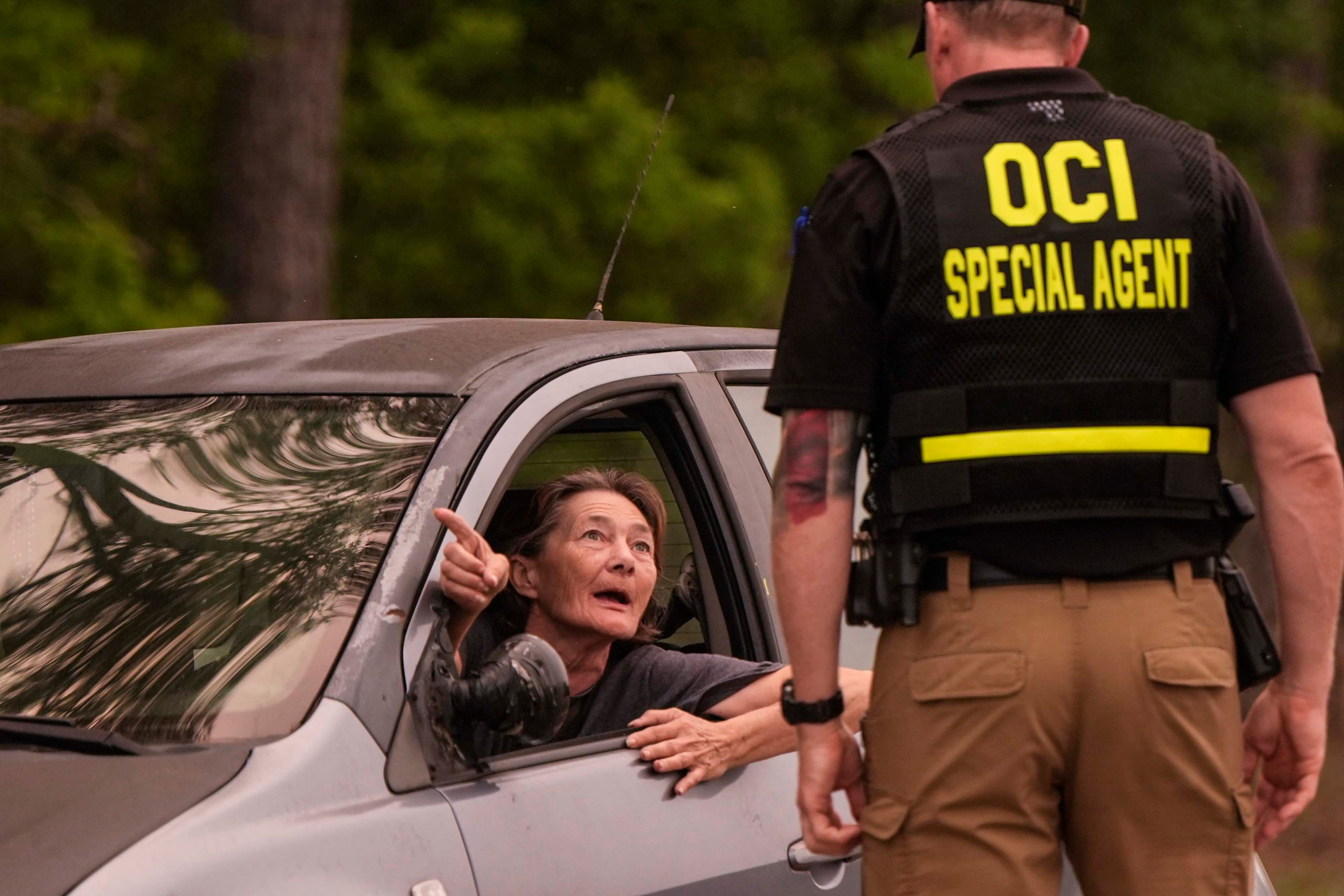 A woman speaks to a state official at a road block in Brantley County, Wednesday, April 22, 2026, near Nahunta, Ga. (Mike Stewart/AP)