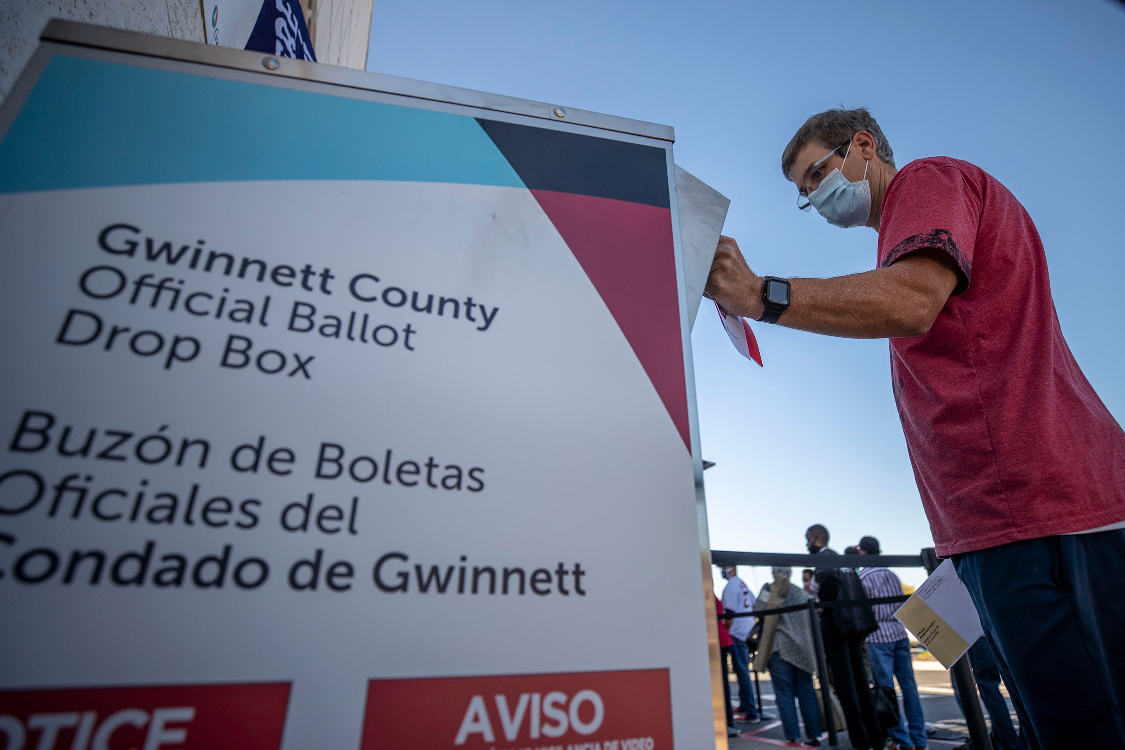 A voter places his absentee ballot inside a drop box in Lawrenceville in 2020. (TNS)