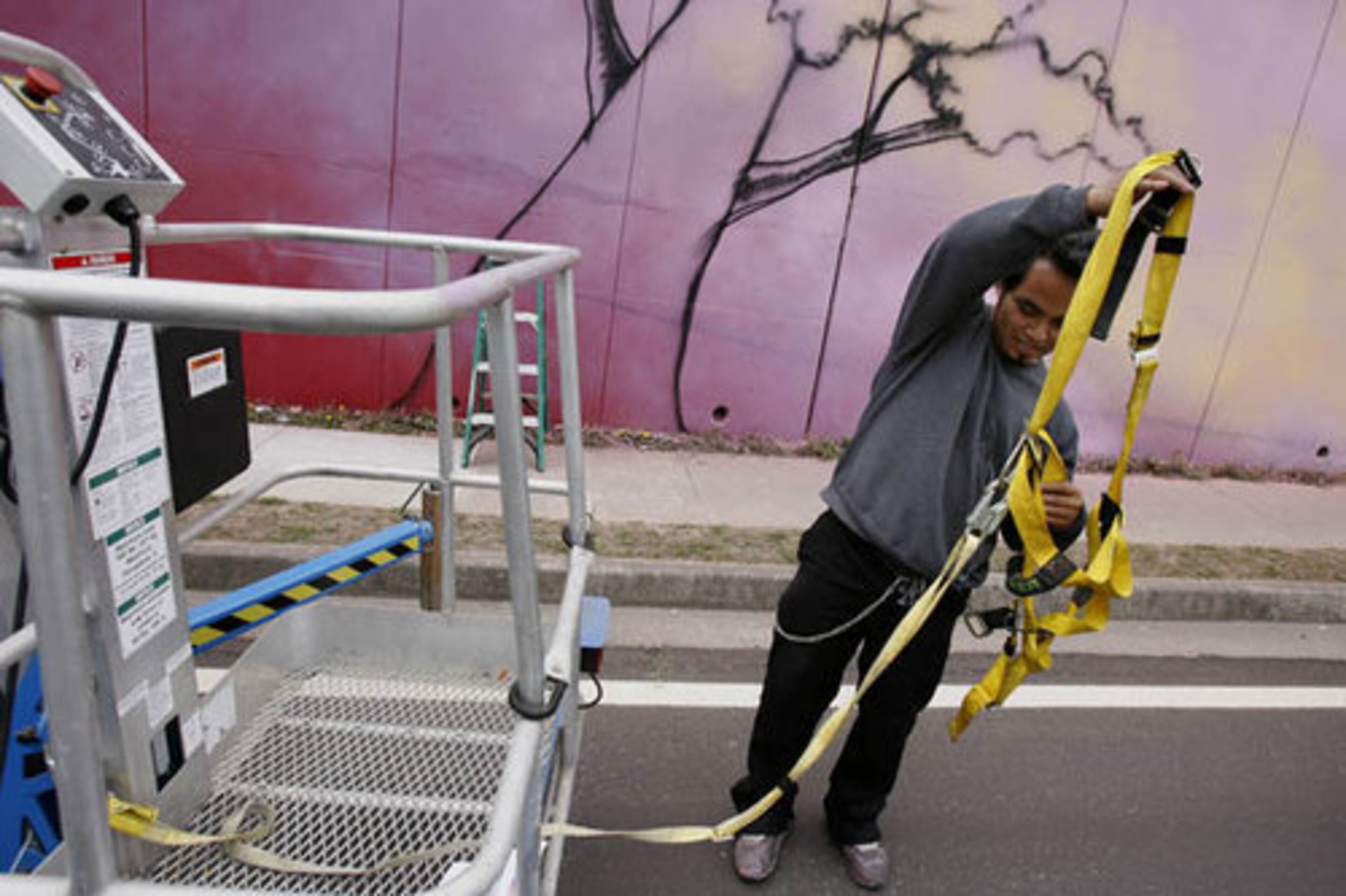 Totem rigs up his lift equipment to get to high spots on the wall.