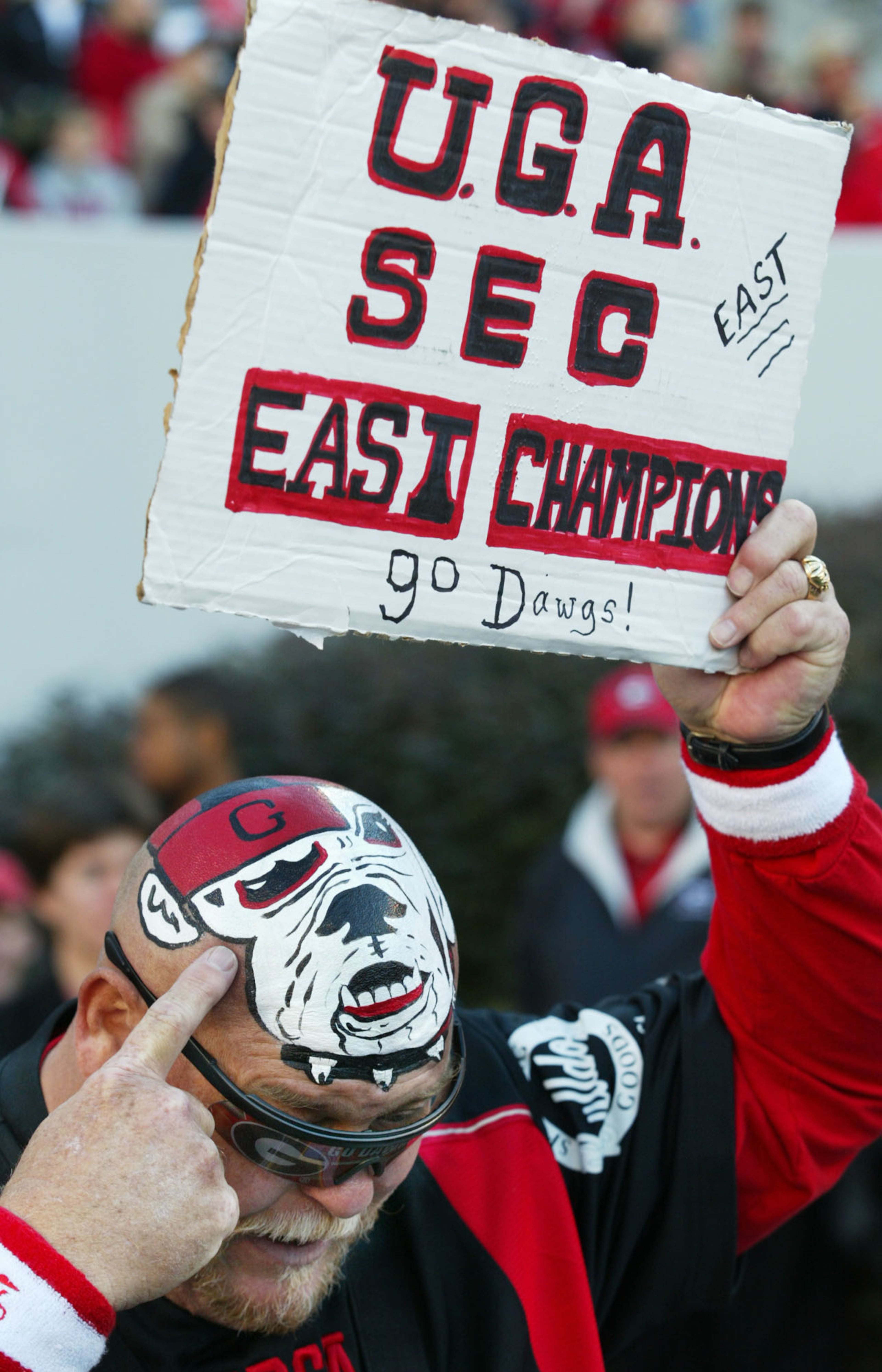 051119, ATHEN, GA: The Saturday, Nov. 19, SEC football game between Georgia and Kentucky in Athens will be televised by Jefferson-Pilot Sports. Georgia fan Mike Woods, from Madison County(GA), points to a bulldog painted on his head and holds up a sign saying "UGA SEC East Champions." (PHOTO BY PHIL SKINNER /staff)