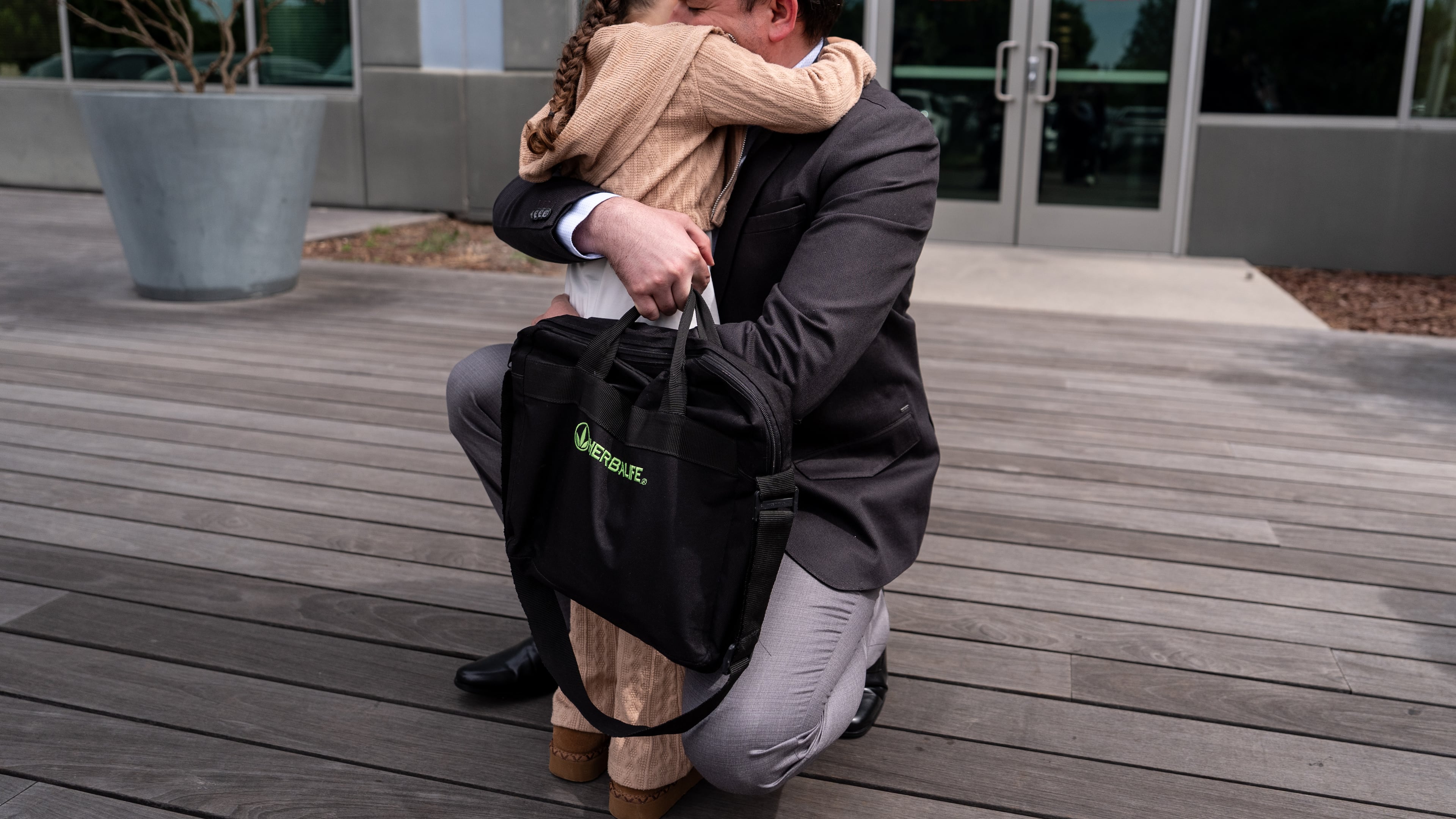 FILE - Milenko Faria, whose wife, Dr. Rubeliz Bolivar, is in immigration custody, hugs their daughter, Milena, after his asylum interview at the U.S. Citizenship and Immigration Services facility in Tustin, Calif., Thursday, April 16, 2026. (AP Photo/Jae C. Hong, File)