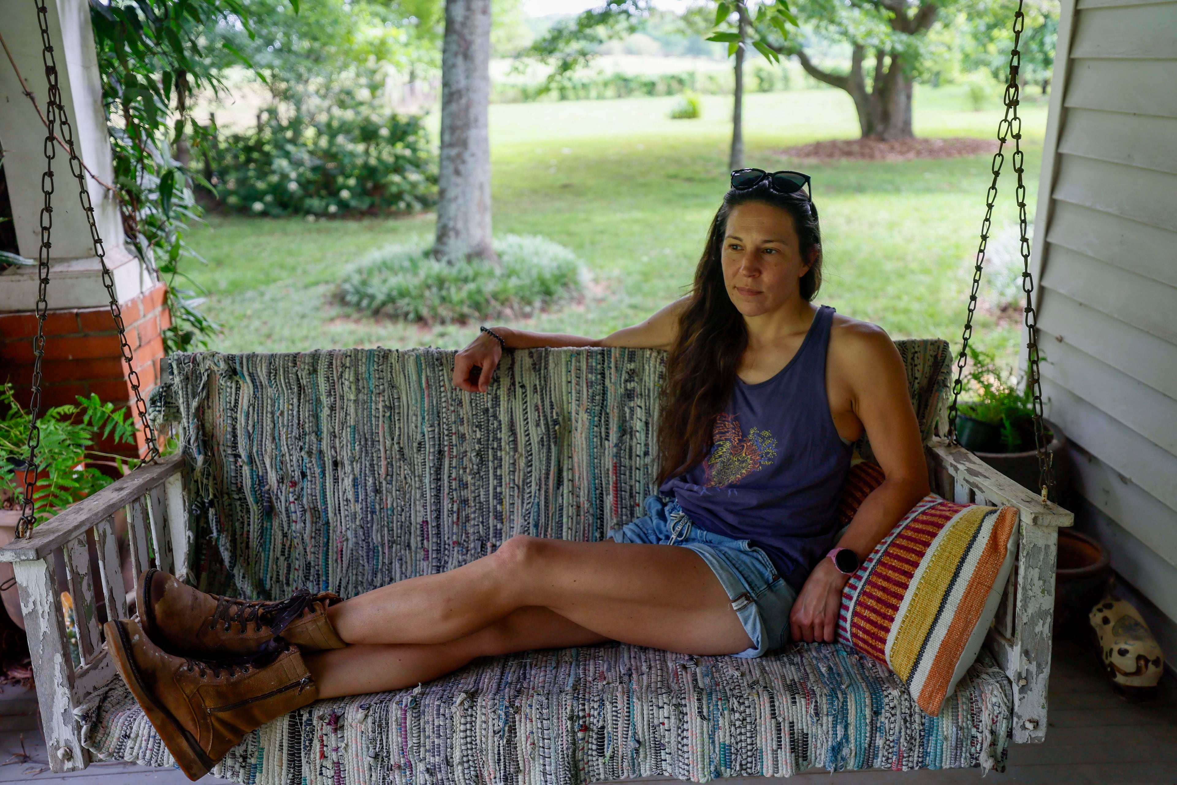 Lori Breedlove is photographed on the porch of the family's 1911 farmhouse, a multigenerational farm outside Watkinsville in Oconee County. A proposed highway bypass would cut through the property. (Miguel Martinez/AJC)