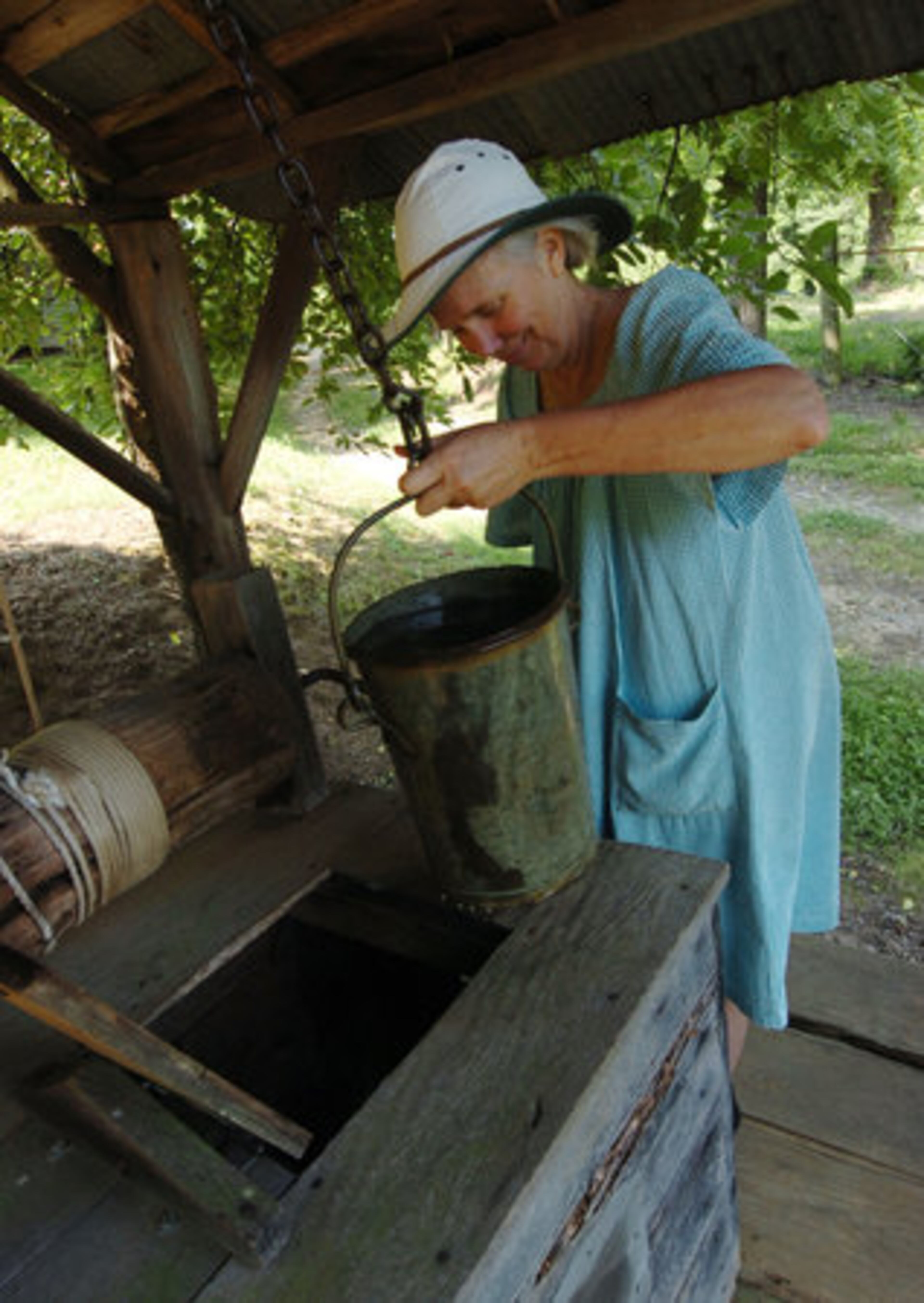 Morning Washburn draws water from a well on the Hyde property.