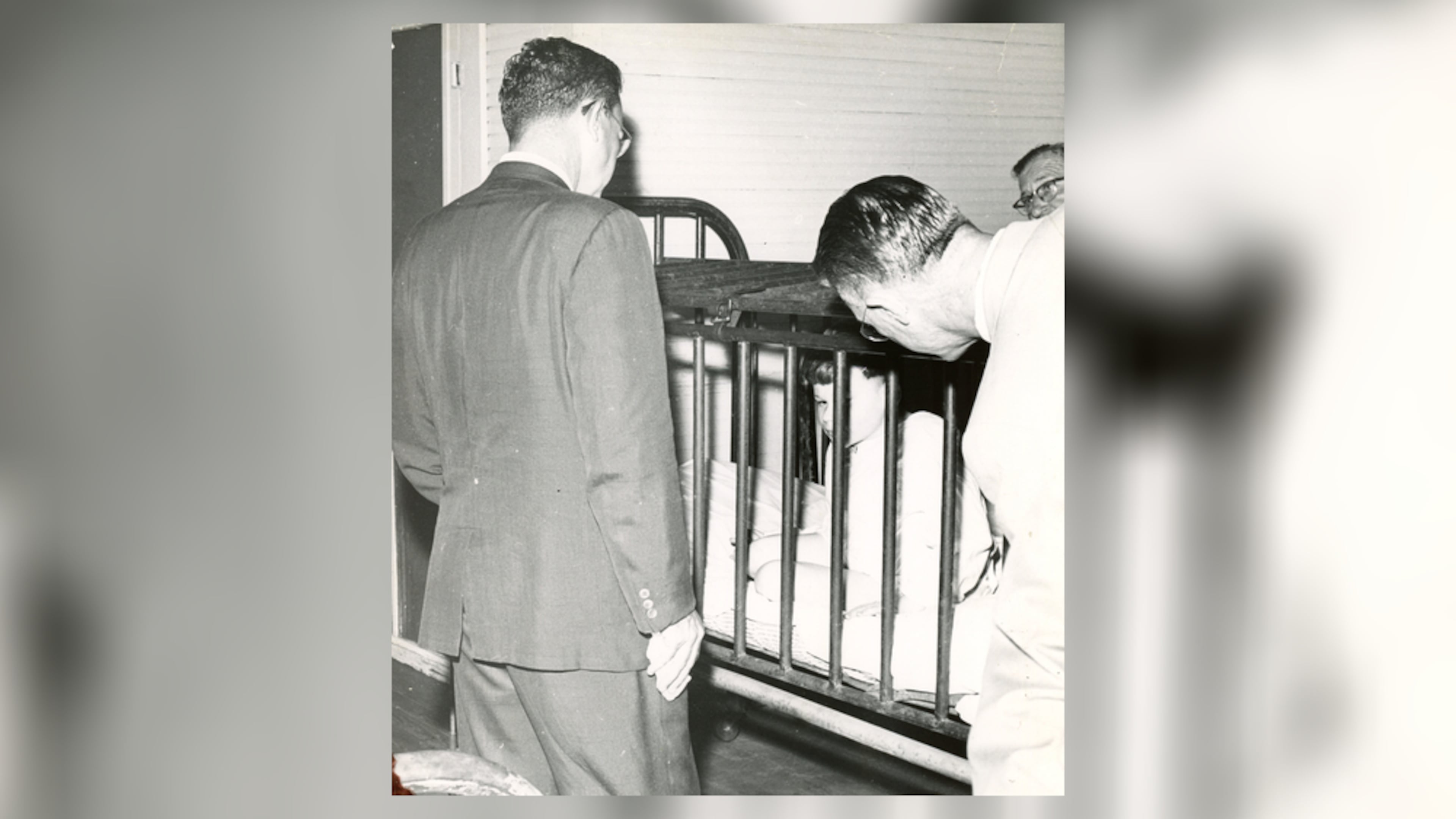 Visitors to Milledgeville State Hospital observe a small boy restrained in a metal cage in the 1940s. The Atlanta Constitution later published a series of stories about conditions at what was then one of the world’s largest mental institutions. (AJC file)