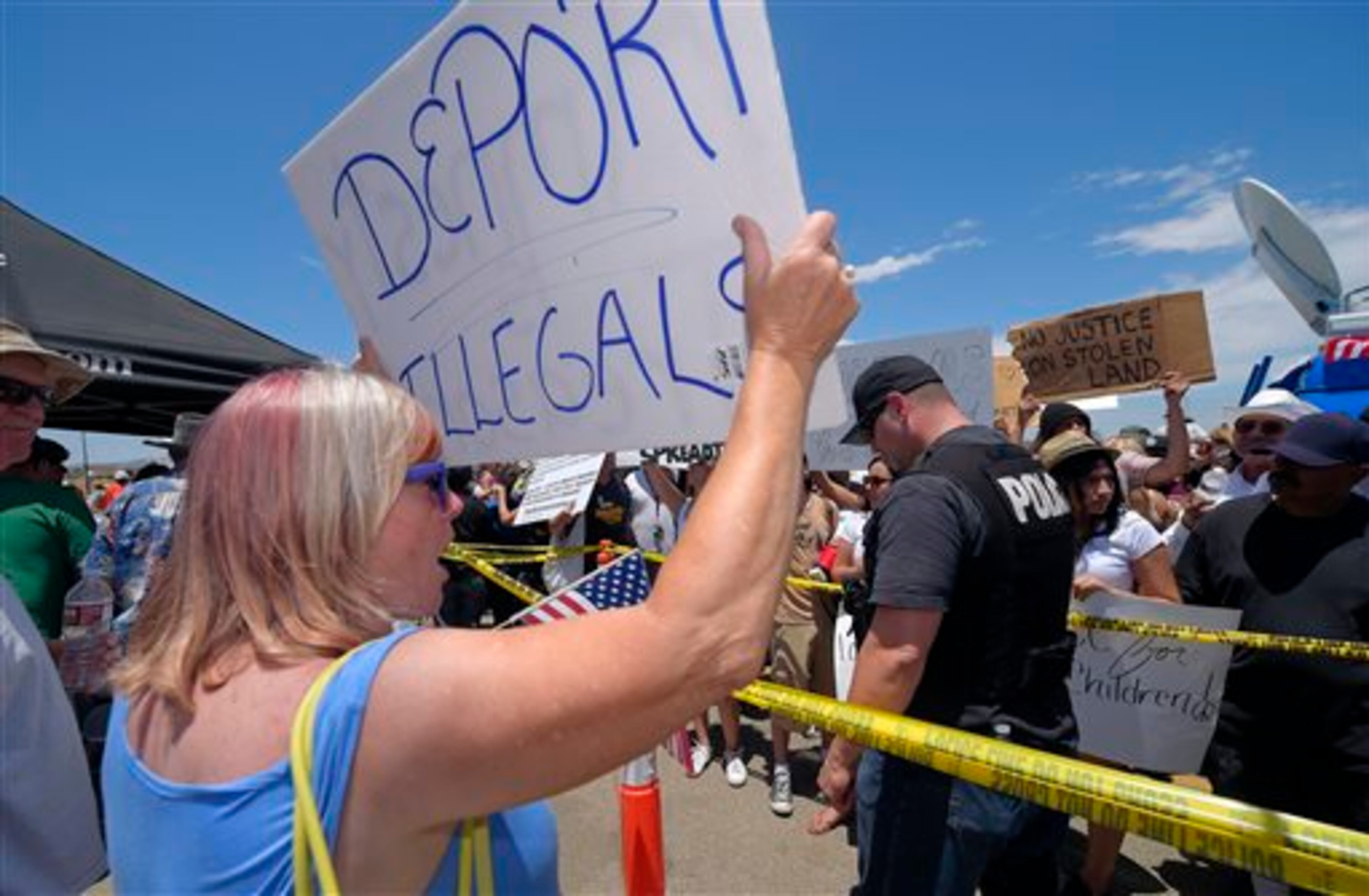 A demonstrator that opposes illegal immigration, left, shouts at immigration supporters, Friday, July 4, 2014, outside a U.S. Border Patrol station in Murrieta, Calif. Demonstrators on both sides of the immigration debate had gathered where the agency was foiled earlier this week in an attempt to bus in and process some of the immigrants who have flooded the Texas border with Mexico. (AP Photo/Mark J. Terrill)