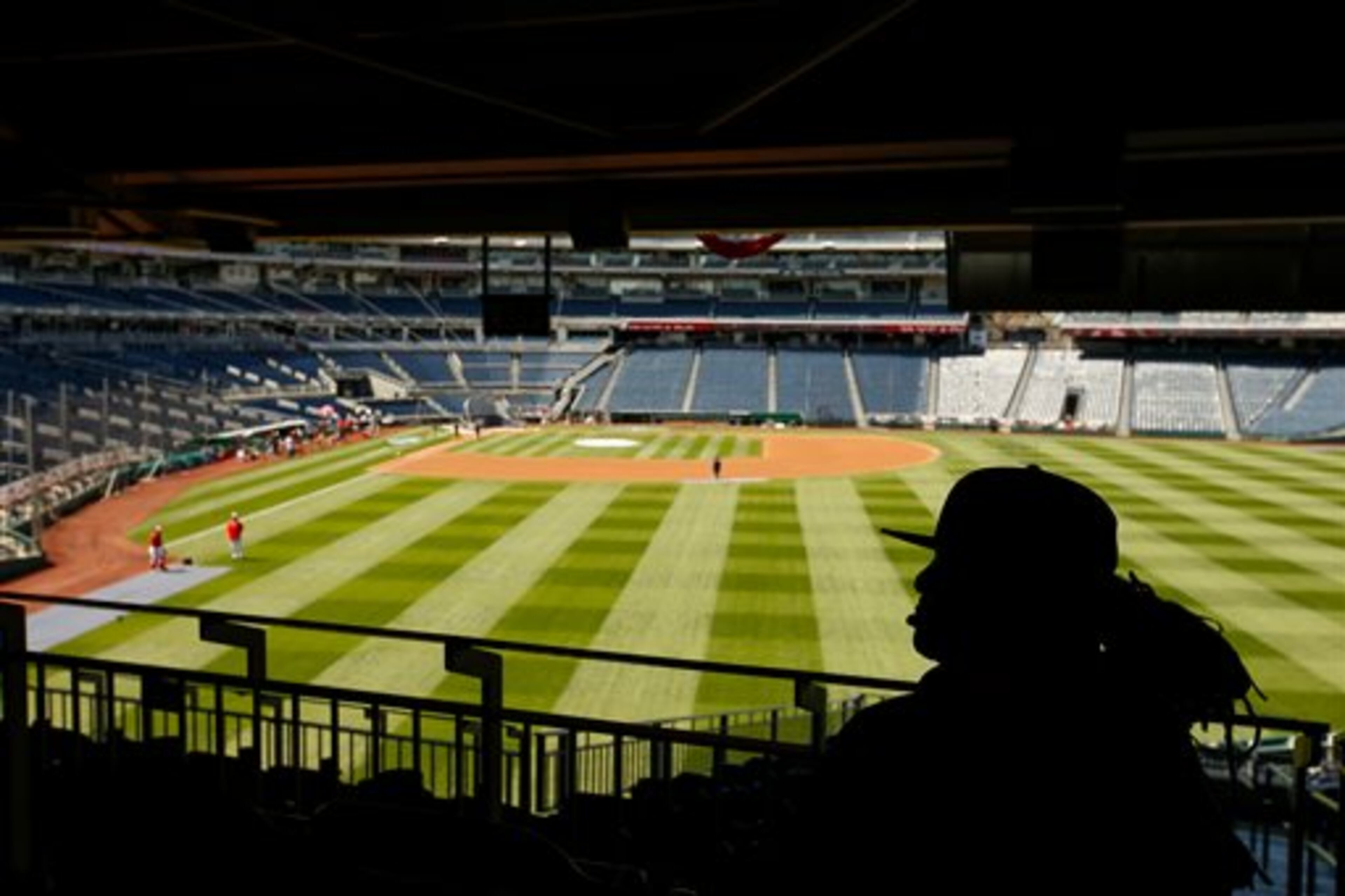 A stadium worker sits above the field before a baseball game between the Washington Nationals and the New York Mets on opening day at Nationals Park, Monday, April 6, 2015, in Washington. (AP Photo/Andrew Harnik)
