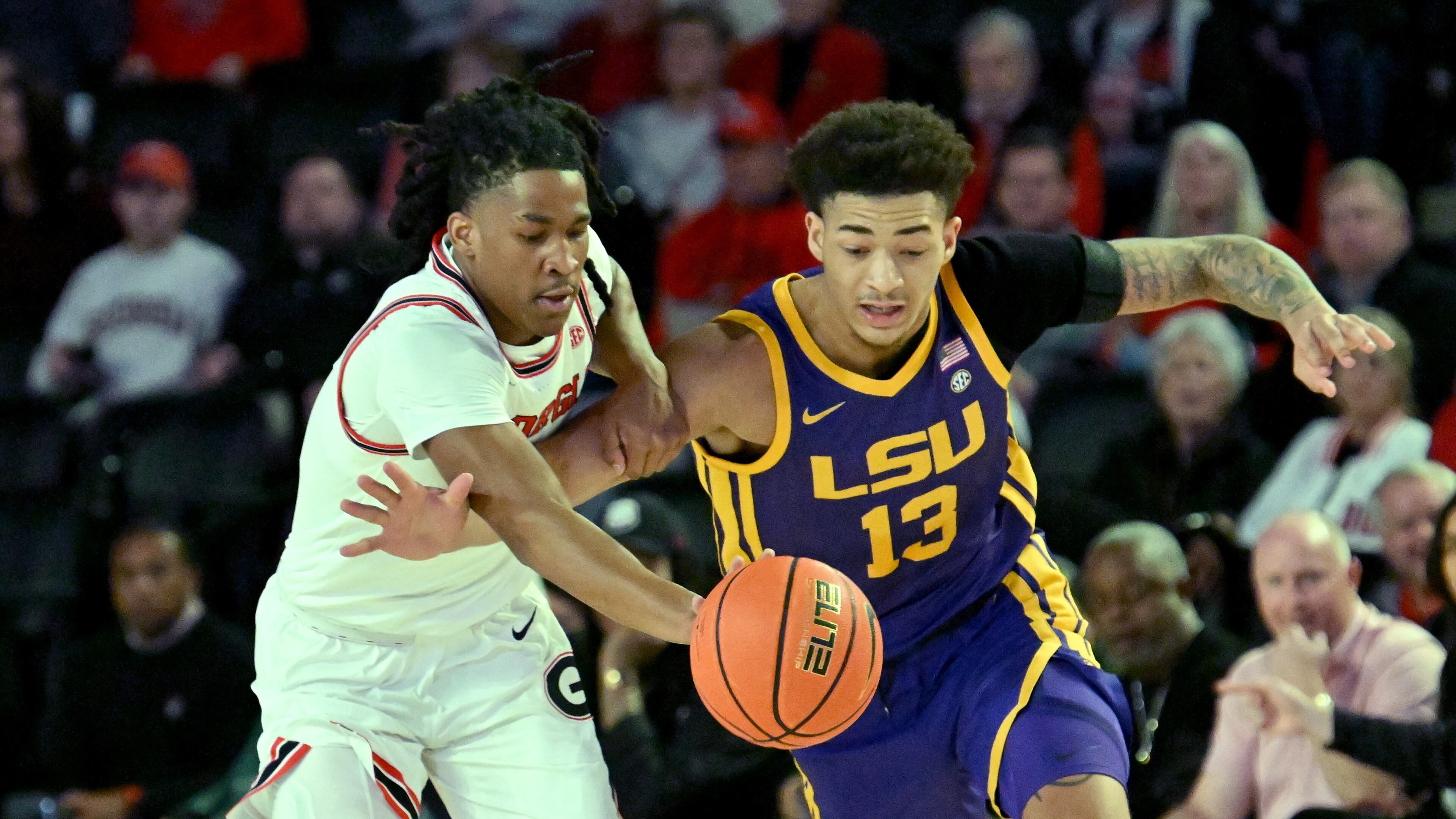 Georgia guard Silas Demary Jr. (left) and LSU forward Jalen Reed (13) fight for a loose ball during the first half of an NCAA college basketball game at Stegeman Coliseum, Wednesday, January 24, 2024, in Athens. (Hyosub Shin / Hyosub.Shin@ajc.com)