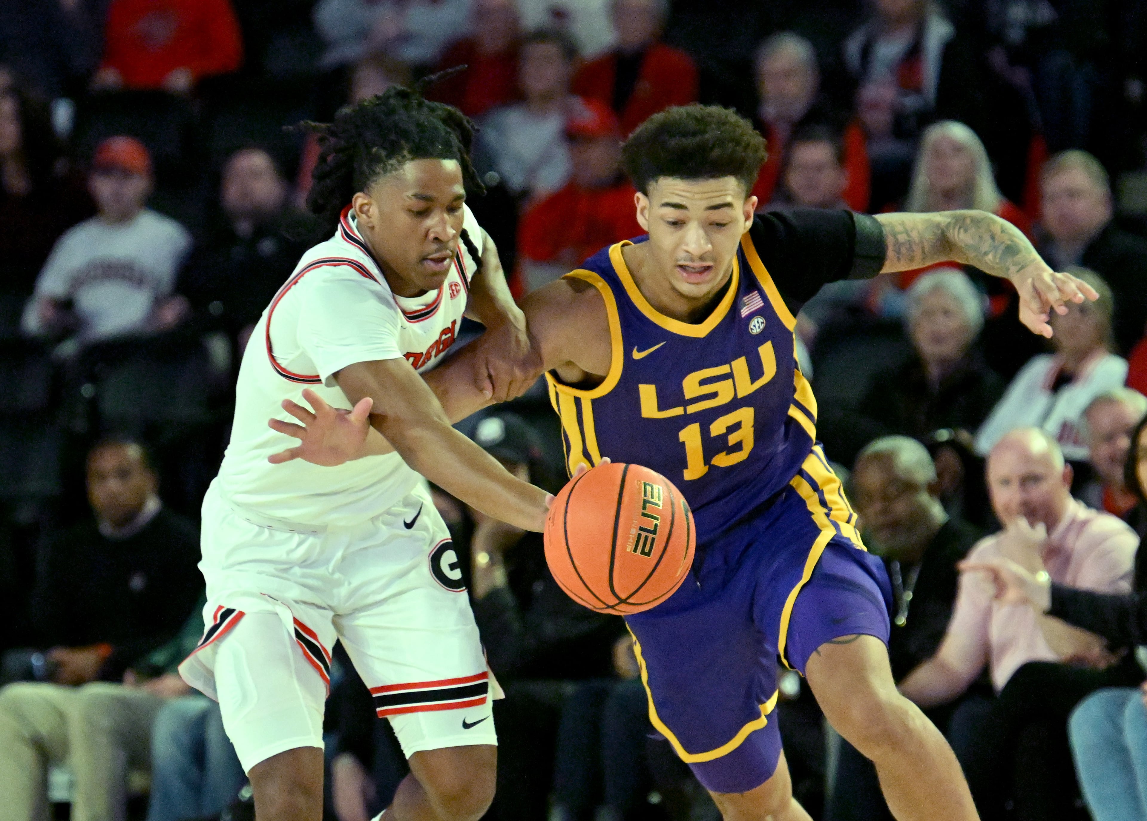 Georgia guard Silas Demary Jr. (left) and LSU forward Jalen Reed (13) fight for a loose ball during the first half of an NCAA college basketball game at Stegeman Coliseum, Wednesday, January 24, 2024, in Athens. (Hyosub Shin / Hyosub.Shin@ajc.com)