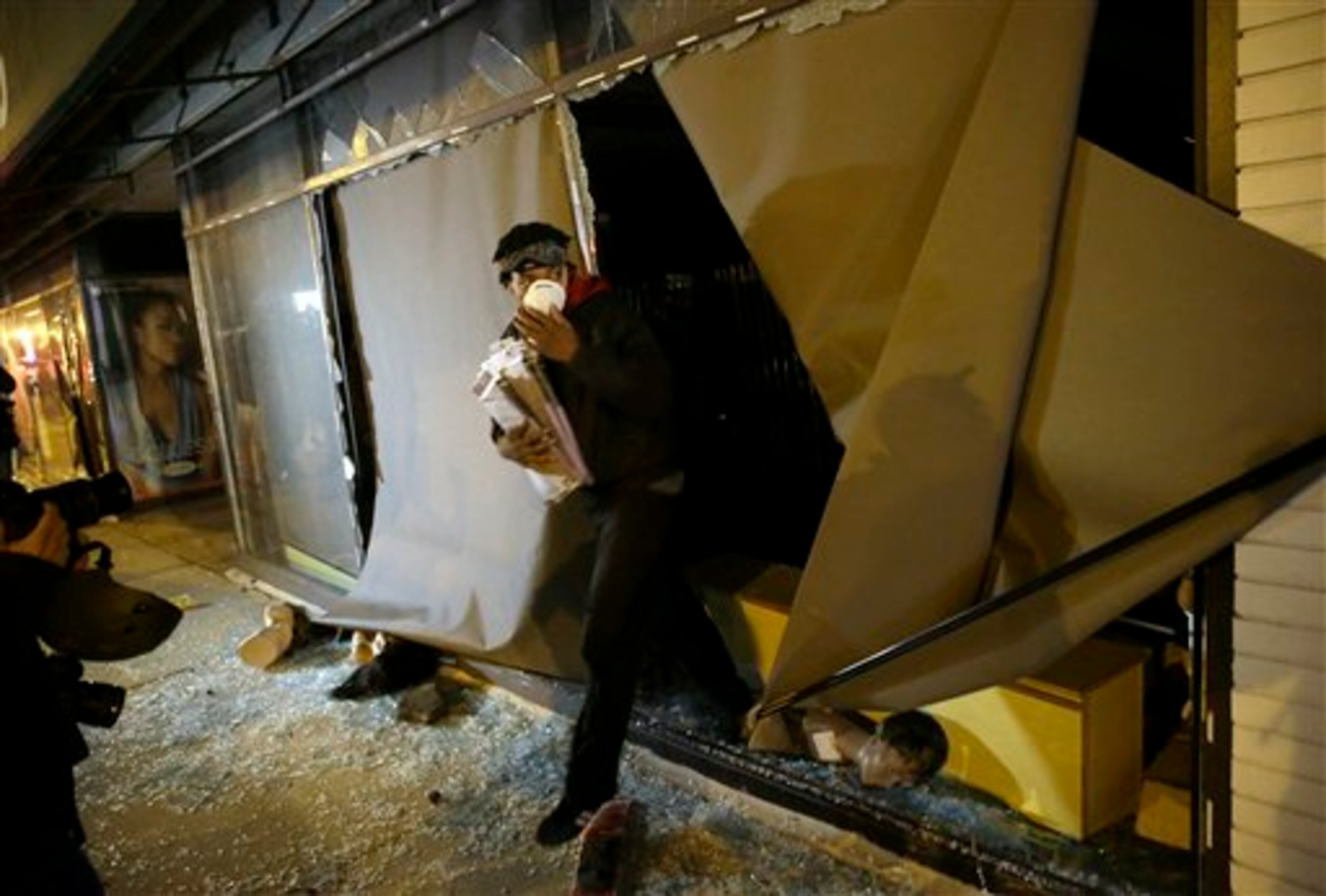 A protester walks out of a store with goods after the announcement of the grand jury decision Monday, Nov. 24, 2014, in Ferguson, Mo. A grand jury has decided not to indict Ferguson police officer Darren Wilson in the death of Michael Brown, the unarmed, black 18-year-old whose fatal shooting sparked sometimes violent protests. (AP Photo/David Goldman)
