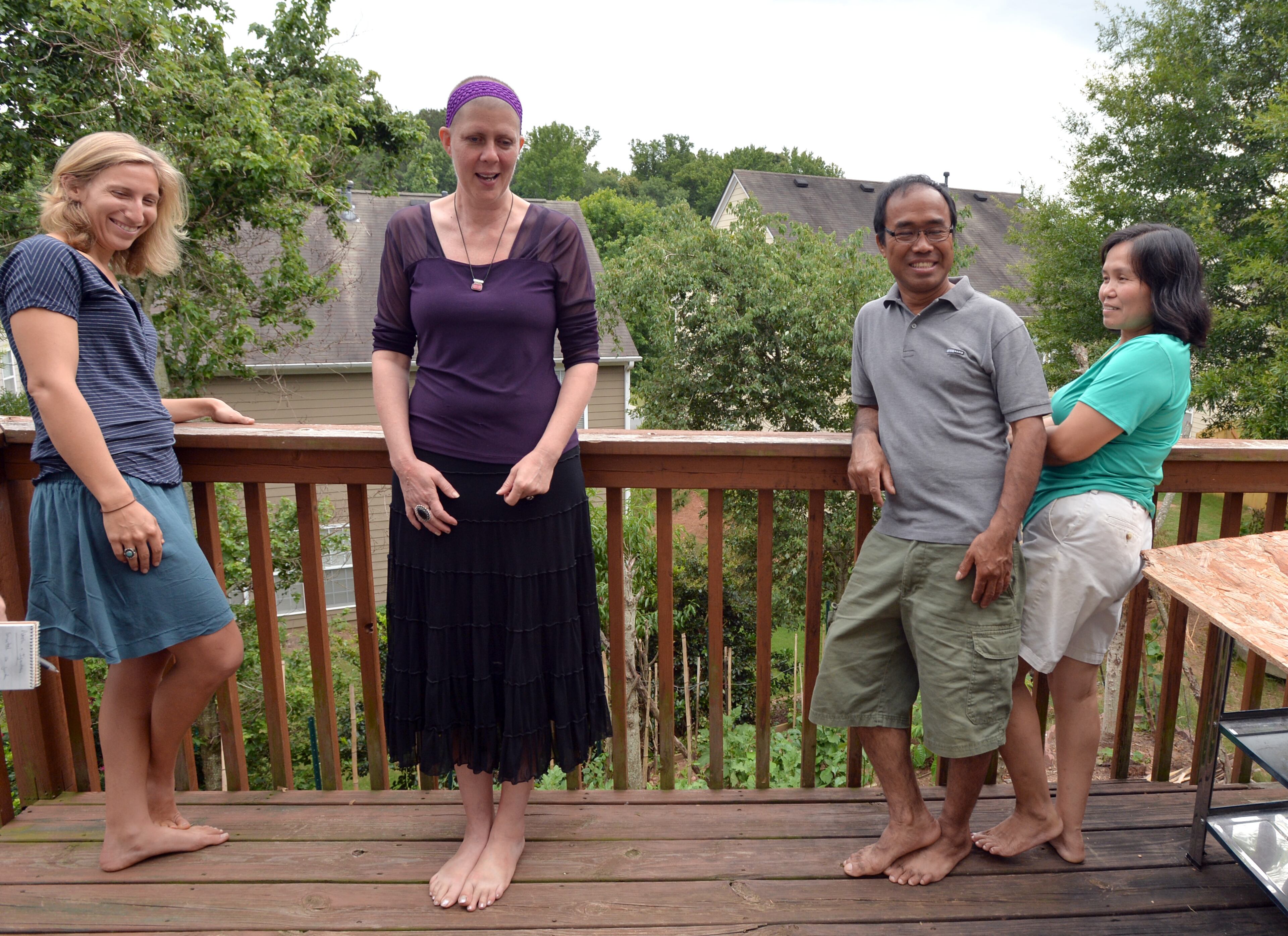 Susan Pavlin (second from left), founder of Global Growers Network, and Robin Chanin (left), director of farm operations, chat with Ignatius Than and his wife Noela Men (right), both from Burma, as they visit the couple's home in Suwanee on Saturday, June 21, 2014. HYOSUB SHIN / HSHIN@AJC.COM