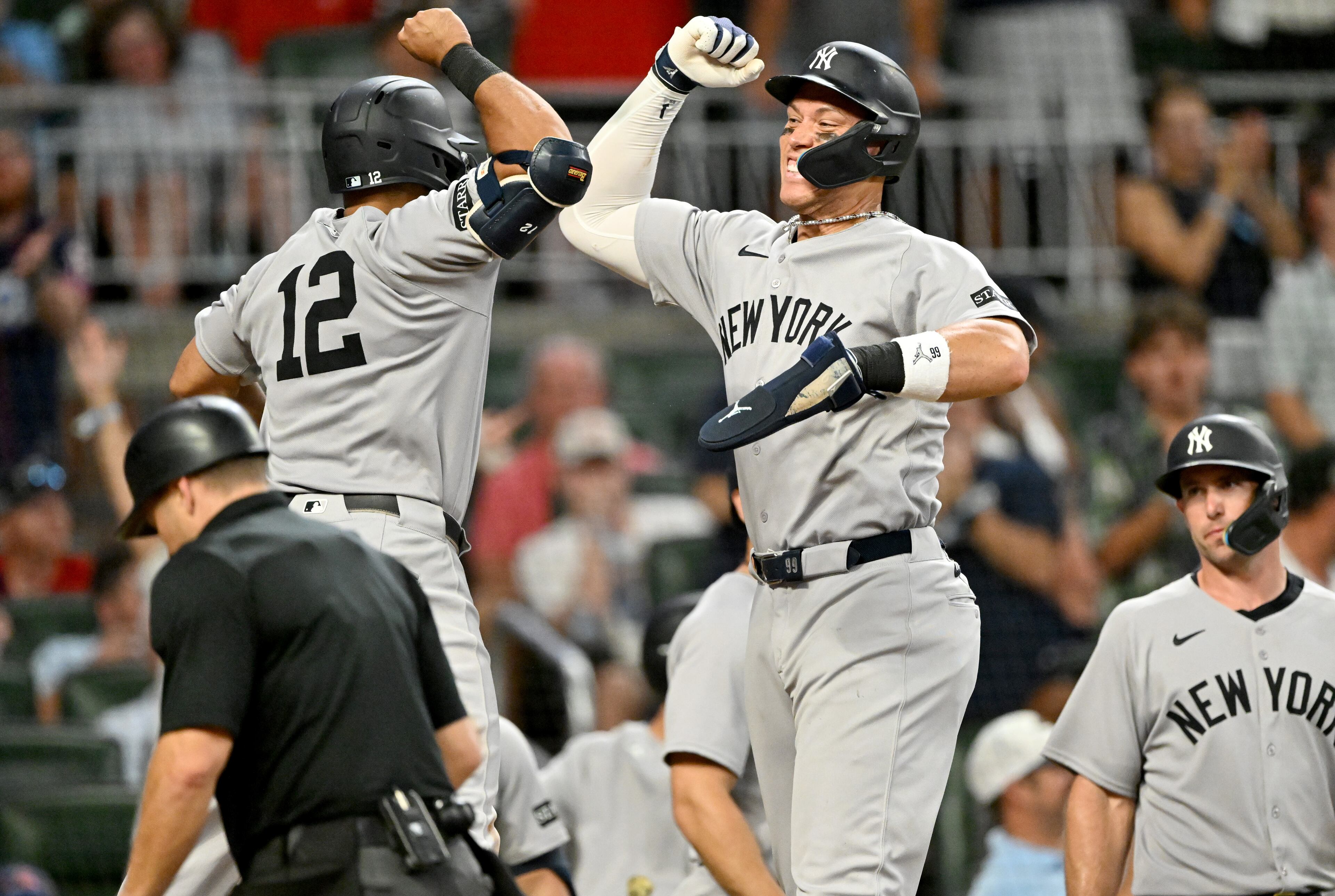 New York Yankees outfielder Trent Grisham (12) celebrates with New York Yankees outfielder Aaron Judge (right) after hitting a grand slam during the ninth inning of a baseball game at Truist Park, Saturday, July 19, 2025, in Atlanta. New York Yankees won 12-9 over Atlanta Braves. (Hyosub Shin / AJC)