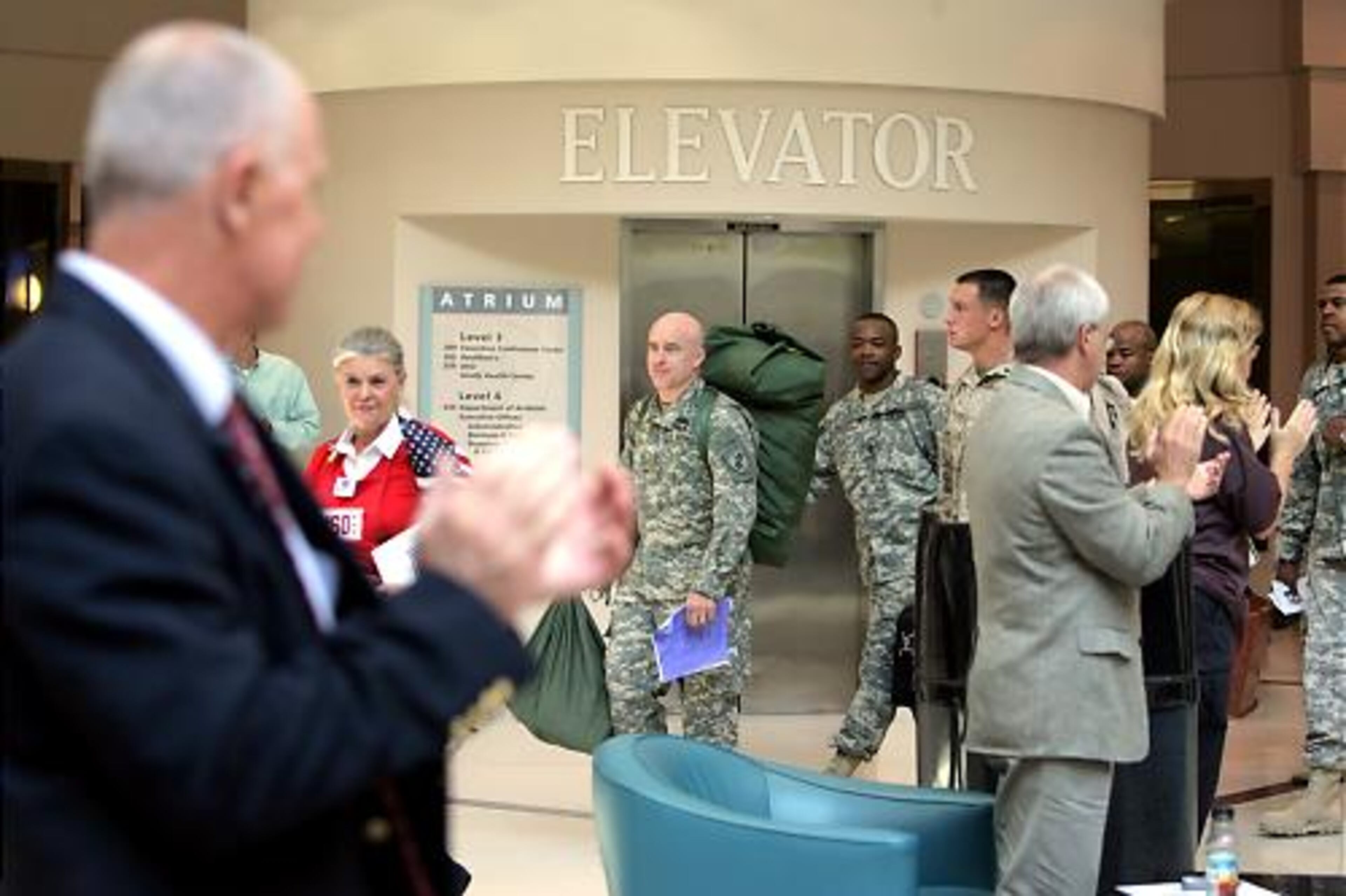 Bette Rose Bowers (left), a USO volunteer, leads soldiers returning to Iraq through the airport's atrium. Next stop: processing stations.