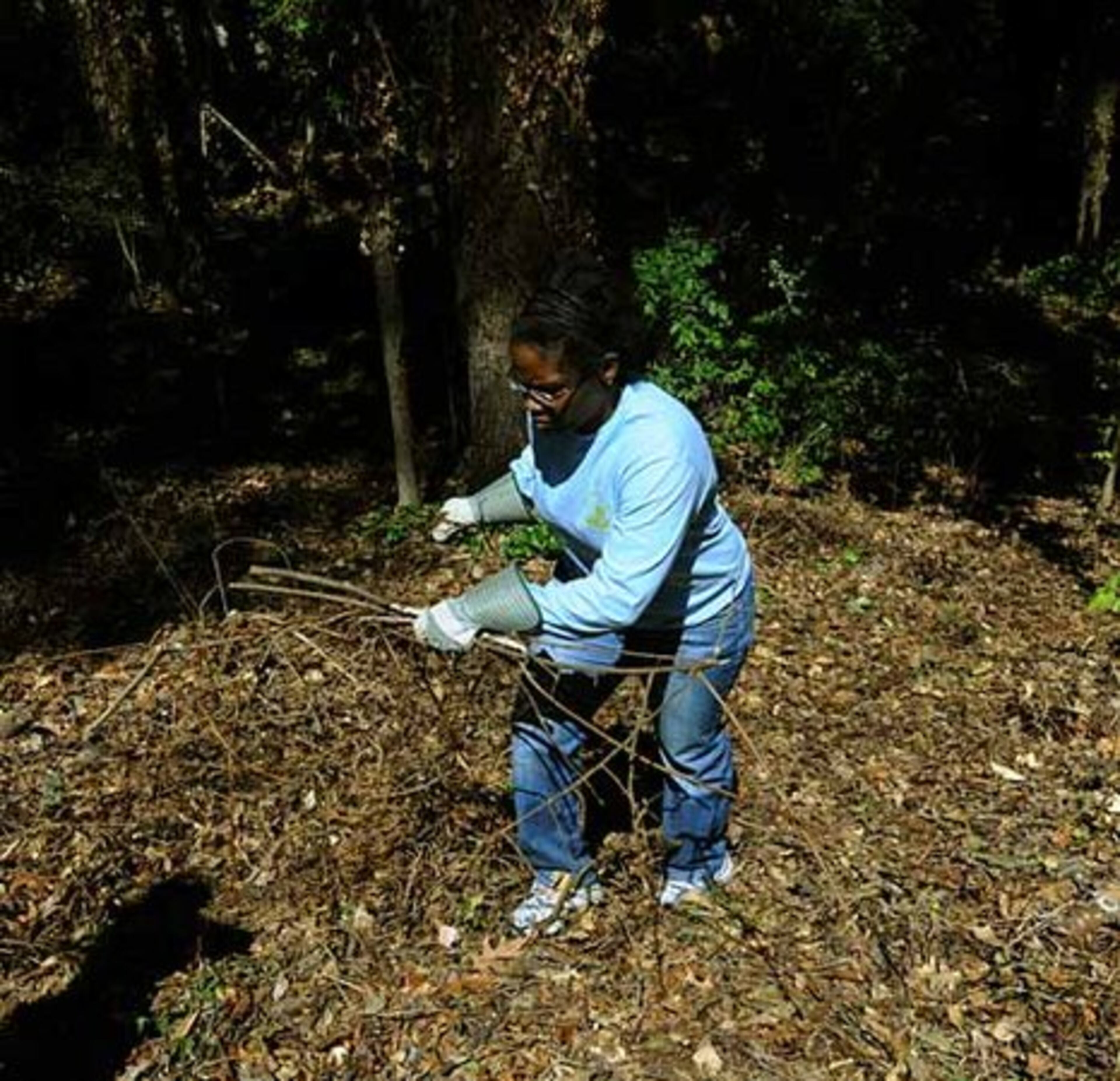 Billie Joe Reynolds, of Suwanee, carries branches and pulls a vine as part of the clean-up effort.