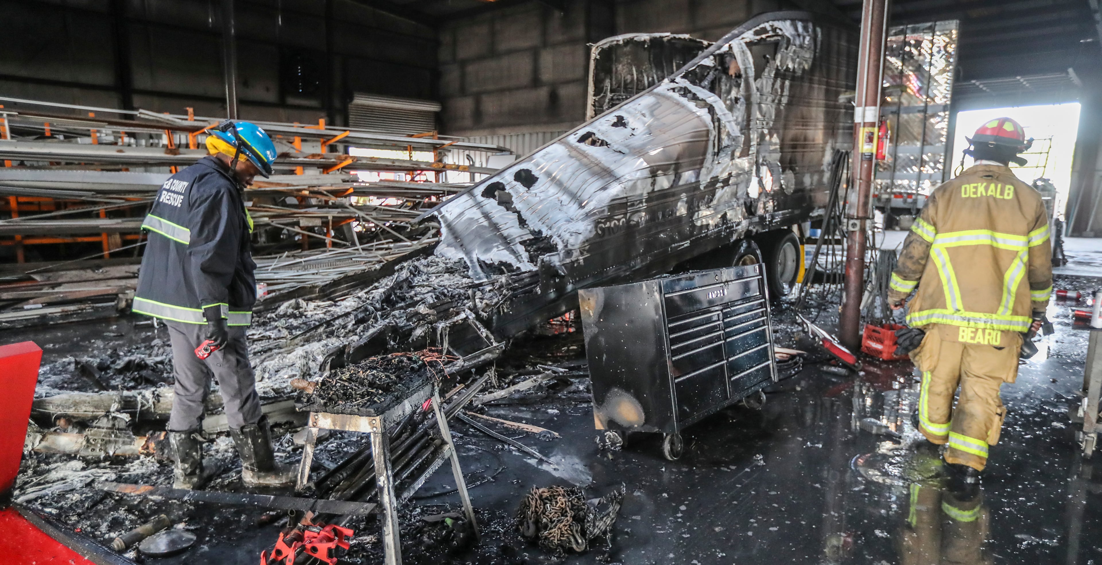 February 14, 2019 DeKalb County: DeKalb County Fire Rescue fire investigator, Henry Patterson (left) examines the truck that caught fire and a worker suffered severe burns in an explosion while he was repairing a semitrailer in DeKalb County on Thursday morning, Feb. 14, 2019. The explosion occurred at a tractor-trailer repair factory in the 4300 block of Old McDonough Road,â DeKalb County Fire Rescue spokesmanâ Dion Bentley said from the scene. Initially, officials said the fire started after the semitrailer crashed into the building. Investigators later determined ìthe injuries were suffered when the patient was working on a trailer, cutting and welding on one of these tractor-trailers you see right there,î Bentley said. The victim suffered burns from the waist up, he said. Bentley said people on the scene heard a large boom before the fire, which remains under investigation. The factory is located near Conley in the southwest corner of DeKalb County. JOHN SPINK/JSPINK@AJC.COM