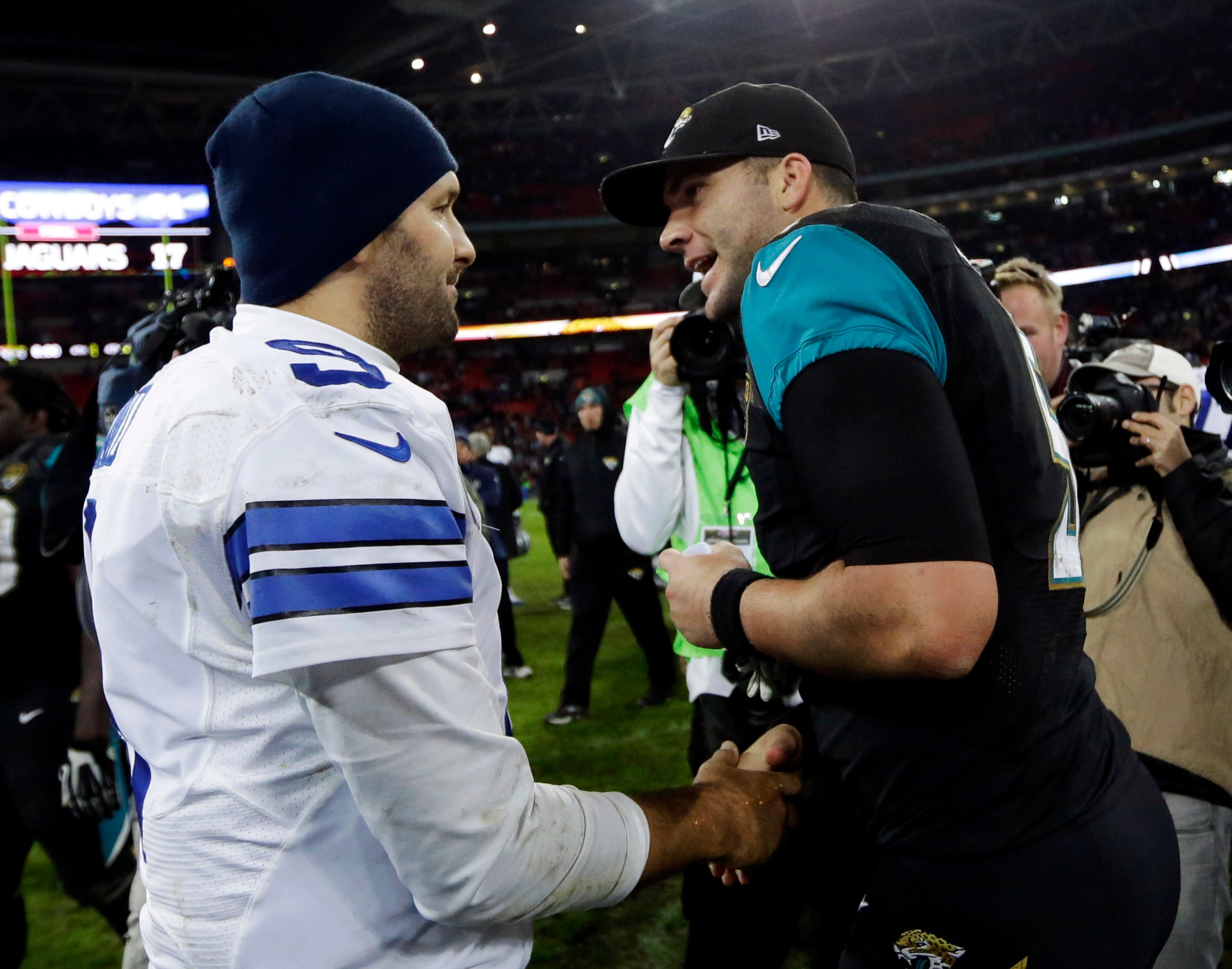Dallas Cowboys quarterback Tony Romo, left, shakes hands with Jacksonville Jaguars quarterback Blake Bortles following their NFL football game at Wembley Stadium, London, Sunday, Nov. 9, 2014. The Cowboys defeated the Jaguars 31-17. (AP Photo/Matt Dunham)