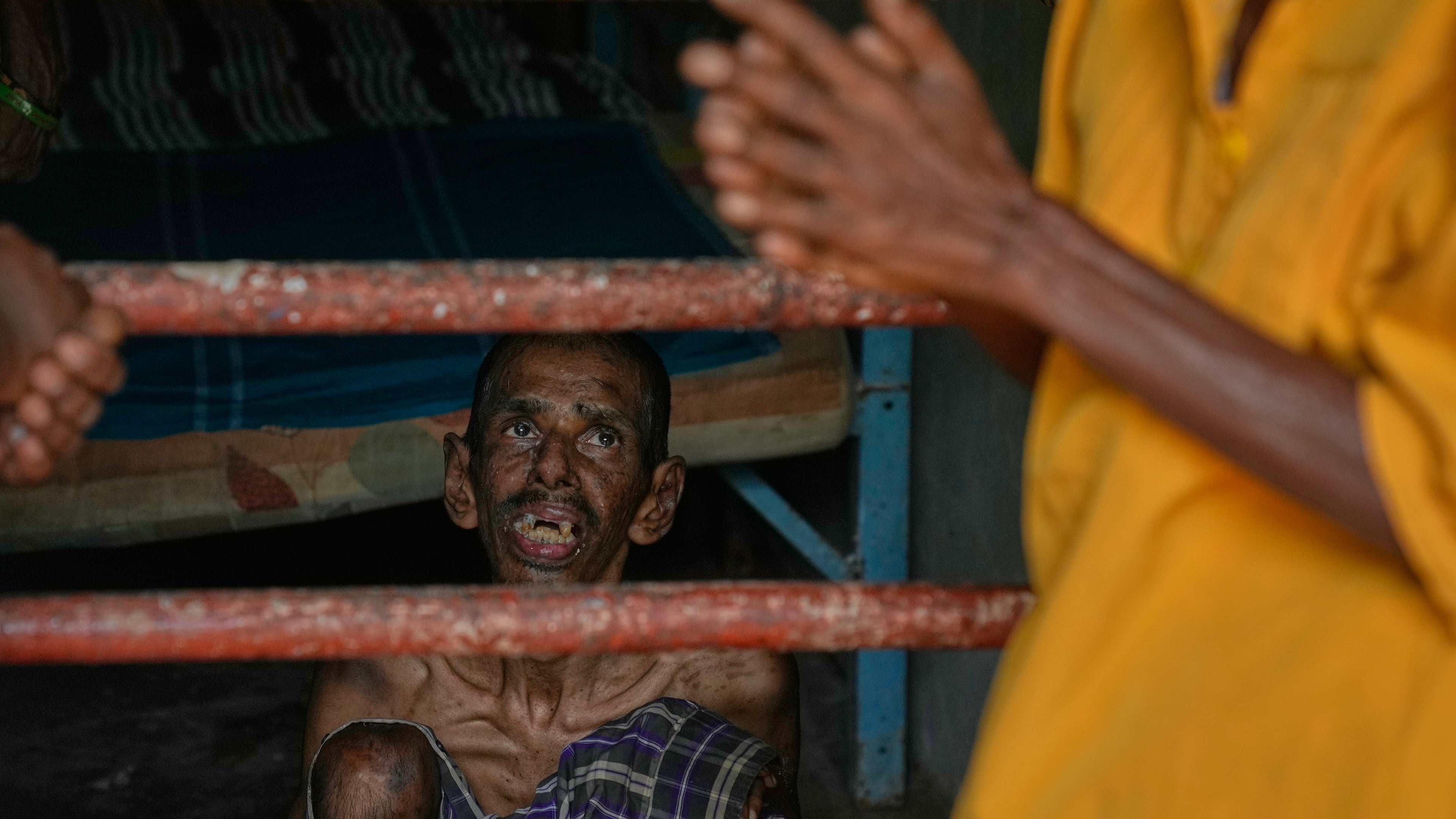 A resident looks at his family members as he sits inside his dormitory at a nursing home in Anguruwatota, Sri Lanka, Friday, June 5, 2026. (AP Photo/Eranga Jayawardena)